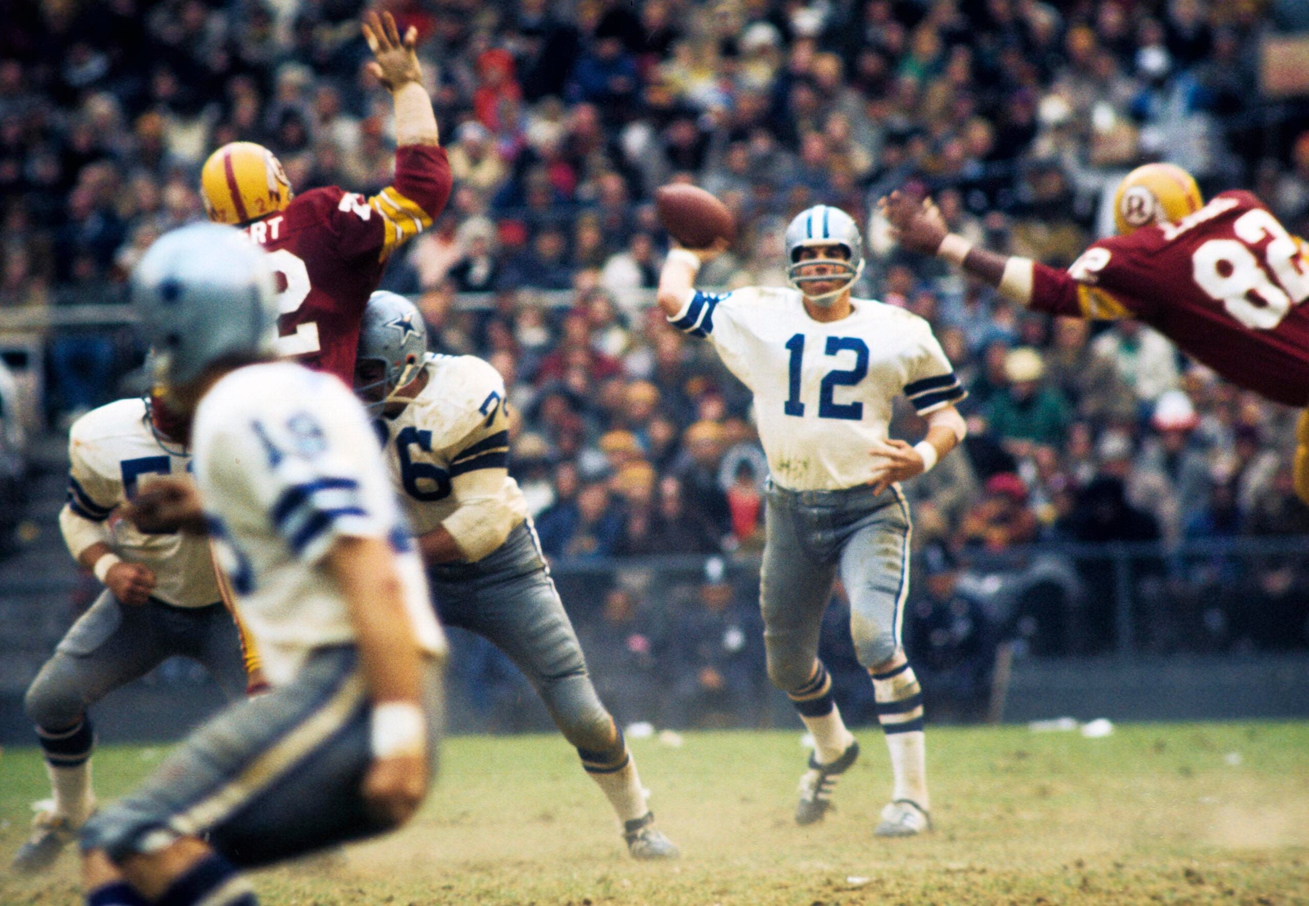 Nov 21, 1971; Washington, DC, USA; FILE PHOTO; Dallas Cowboys quarterback Roger Staubach (12) is pressured by Washington Redskins defensive end Jimmie Jones (82) at RFK Stadium.