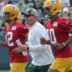 Green Bay Packers quarterbacks coach Luke Getsy runs between quarterback Aaron Rodgers (12) and quarterback Jordan Love (10) during the second day of training camp Thursday, July 29, 2021 in Green Bay, Wis.