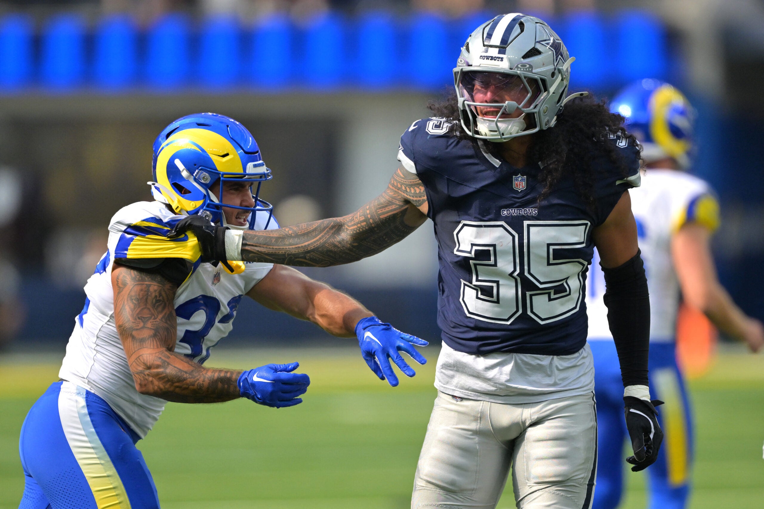 Aug 9, 2025; Inglewood, California, USA; Dallas Cowboys linebacker Marist Liufau (35) grabs a hold of Los Angeles Rams running back Cody Schrader (32) following a play inthe first half at SoFi Stadium.