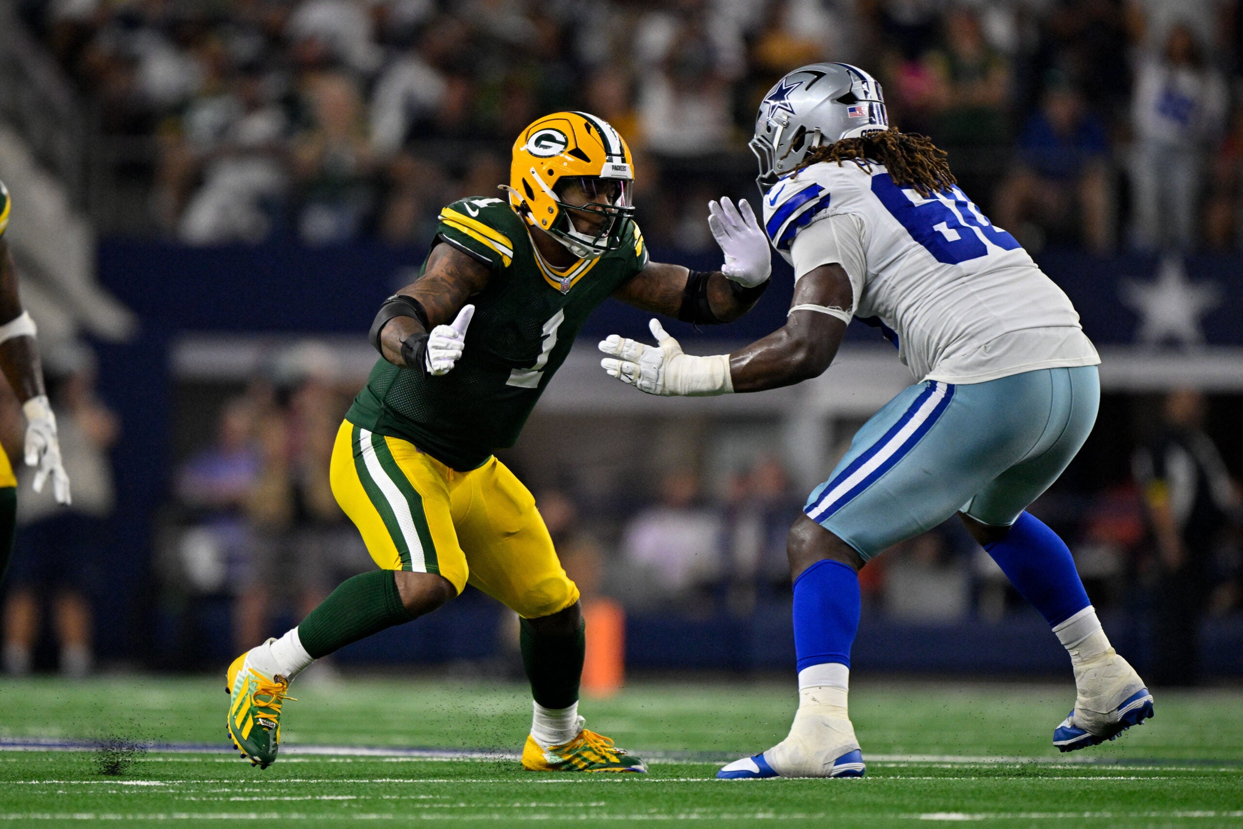 Sep 28, 2025; Arlington, Texas, USA; Dallas Cowboys offensive tackle Tyler Guyton (60) drops back to block the rush of Green Bay Packers defensive end Micah Parsons (1) during the game between the Dallas Cowboys and the Green Bay Packers at AT&T Stadium.