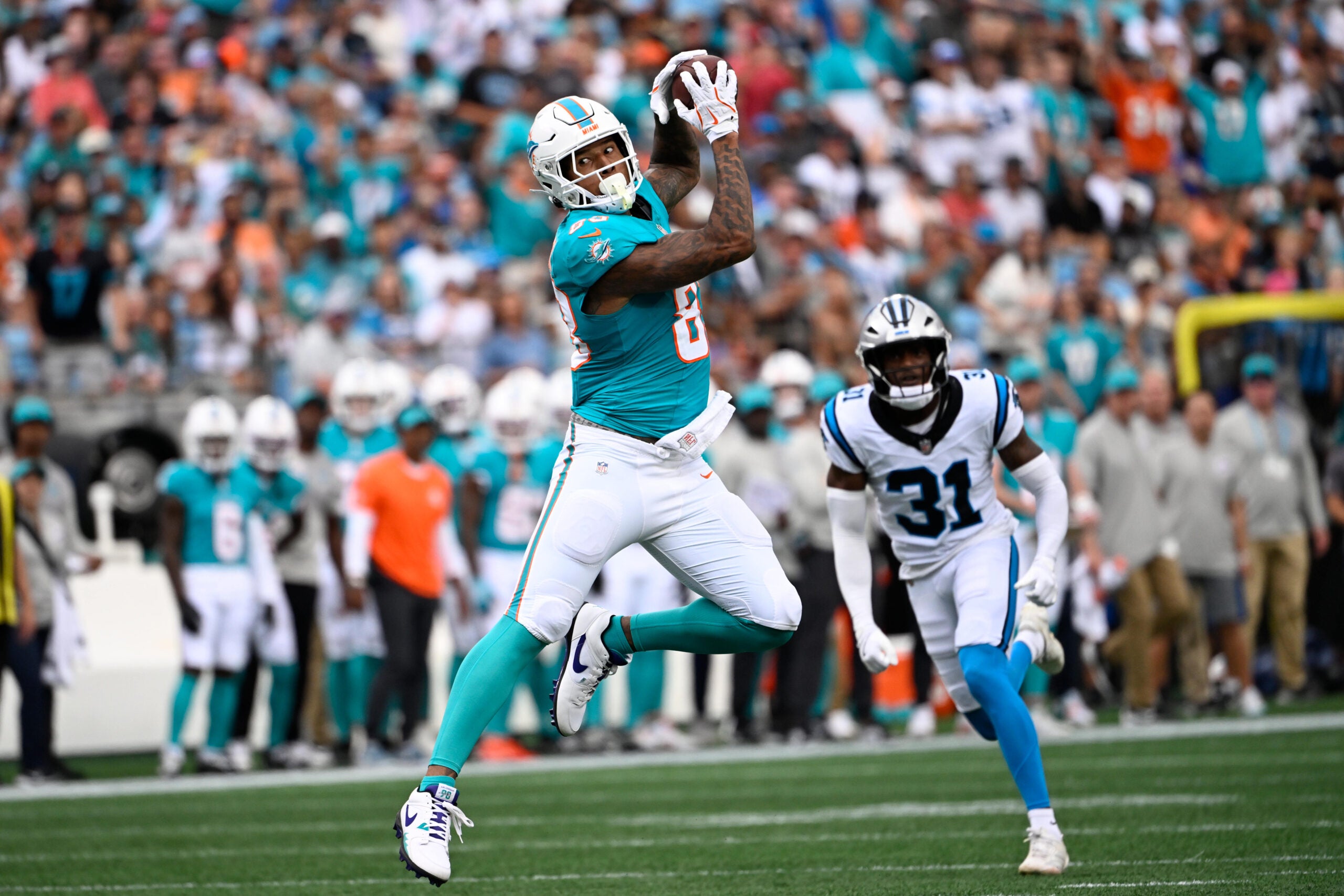Oct 5, 2025; Charlotte, North Carolina, USA; Miami Dolphins tight end Darren Waller (83) catches the ball as Carolina Panthers cornerback Corey Thornton (31) defends in the first quarter at Bank of America Stadium.