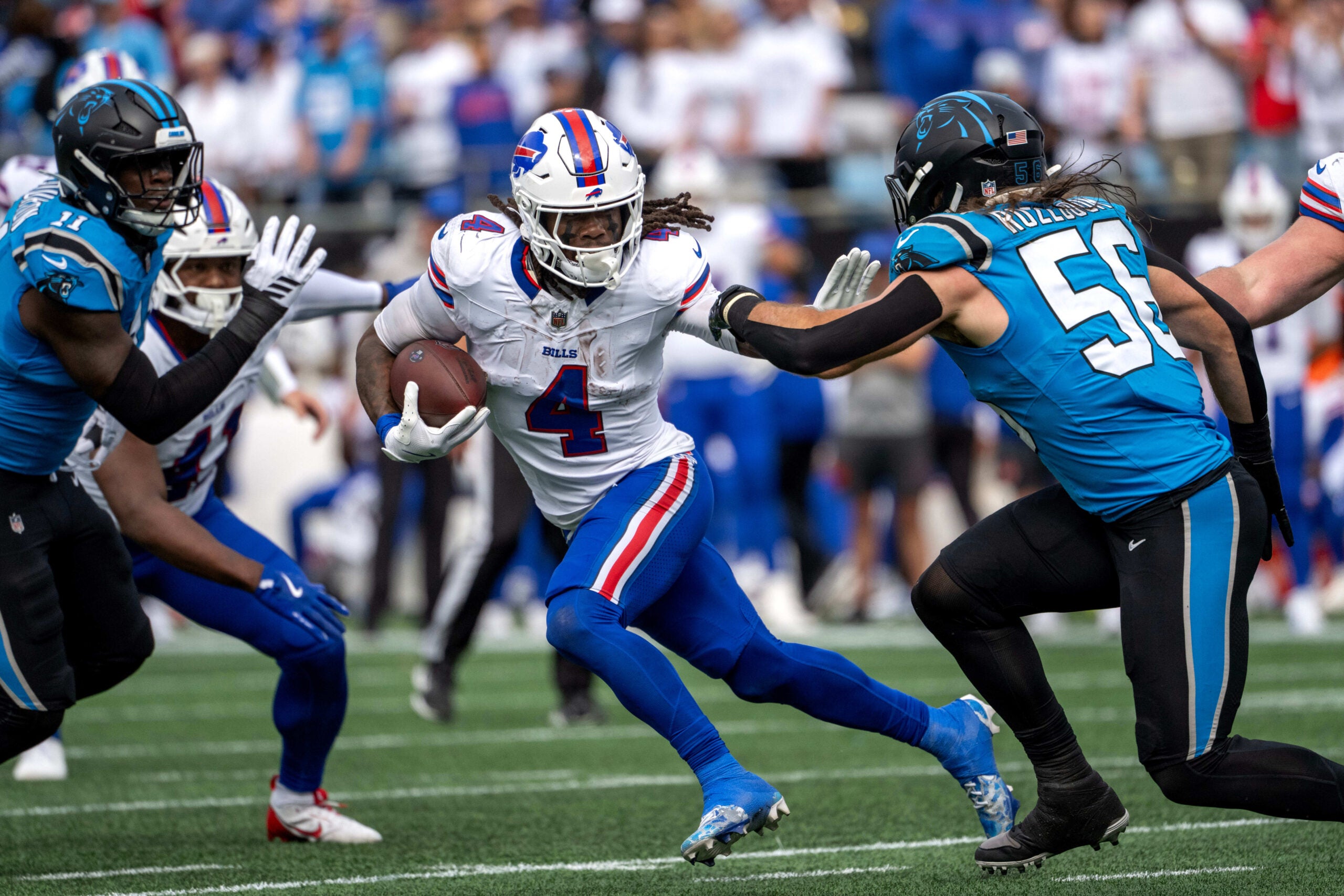 Oct 26, 2025; Charlotte, North Carolina, USA; Buffalo Bills running back James Cook III (4) with the ball as Carolina Panthers linebacker Nic Scourton (11) and linebacker Christian Rozeboom (56) defend in the first quarter at Bank of America Stadium.