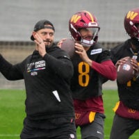 Nov 13, 2025; Madrid, Spain; Washington Commanders assistant quarterbacks coach David Blough (left) and quarterbacks Marcus Mariota (8) and Josh Johnson (14) throw the ball during practice at Ciudad Deportiva del Real Madrid.