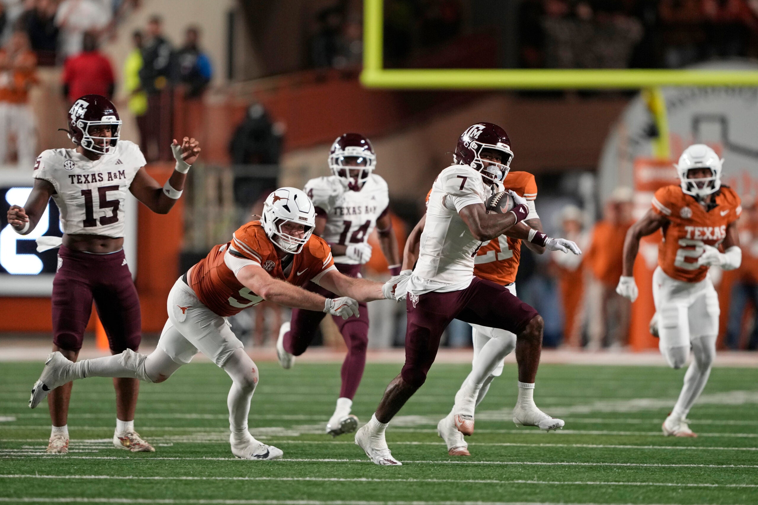 Nov 28, 2025; Austin, Texas, USA; Texas A&M Aggies wide receiver KC Concepcion (7) returns a punt while defended by defensive lineman Ethan Burke (91) during the first half against the Texas Longhorns at Darrell K Royal-Texas Memorial Stadium.