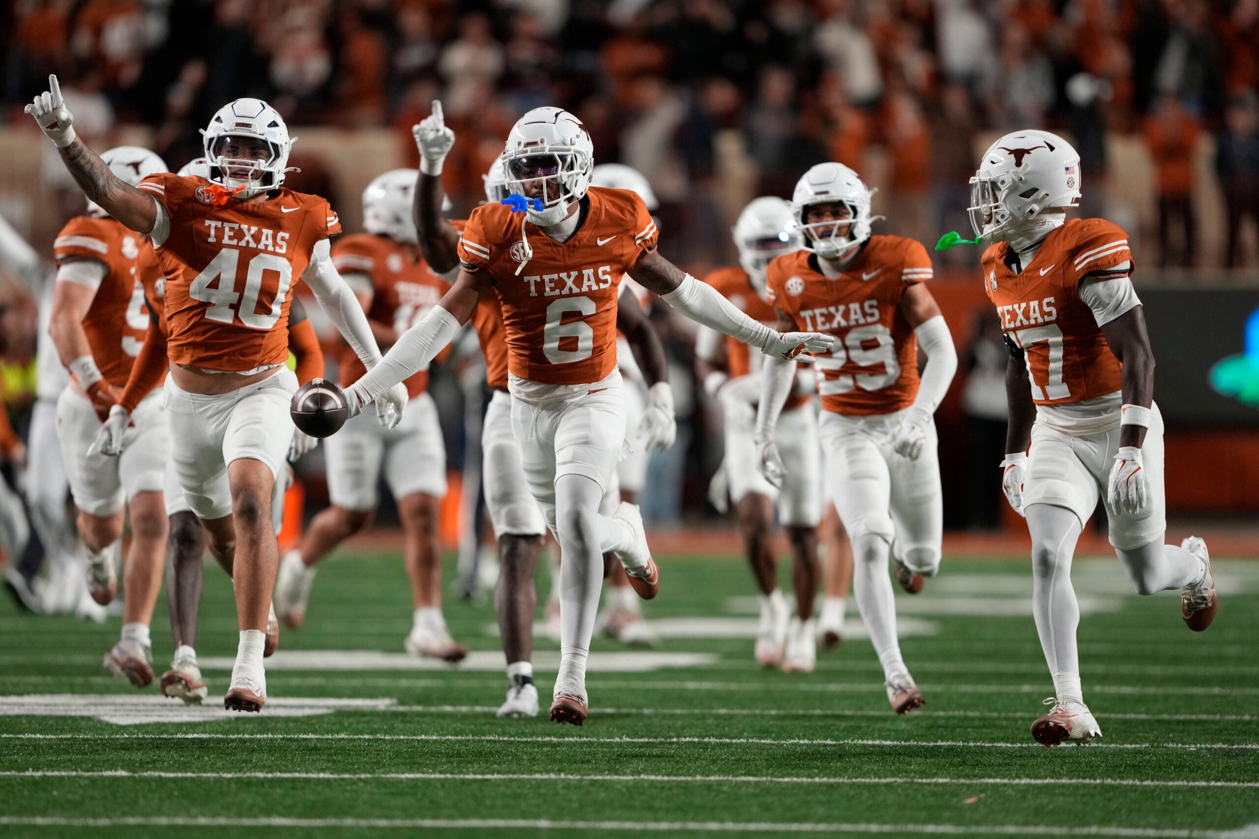 Nov 28, 2025; Austin, Texas, USA; Texas Longhorns defensive back Kobe Black (6) and teammates react after making an interception during the second half against the Texas A&M Aggies at Darrell K Royal-Texas Memorial Stadium.