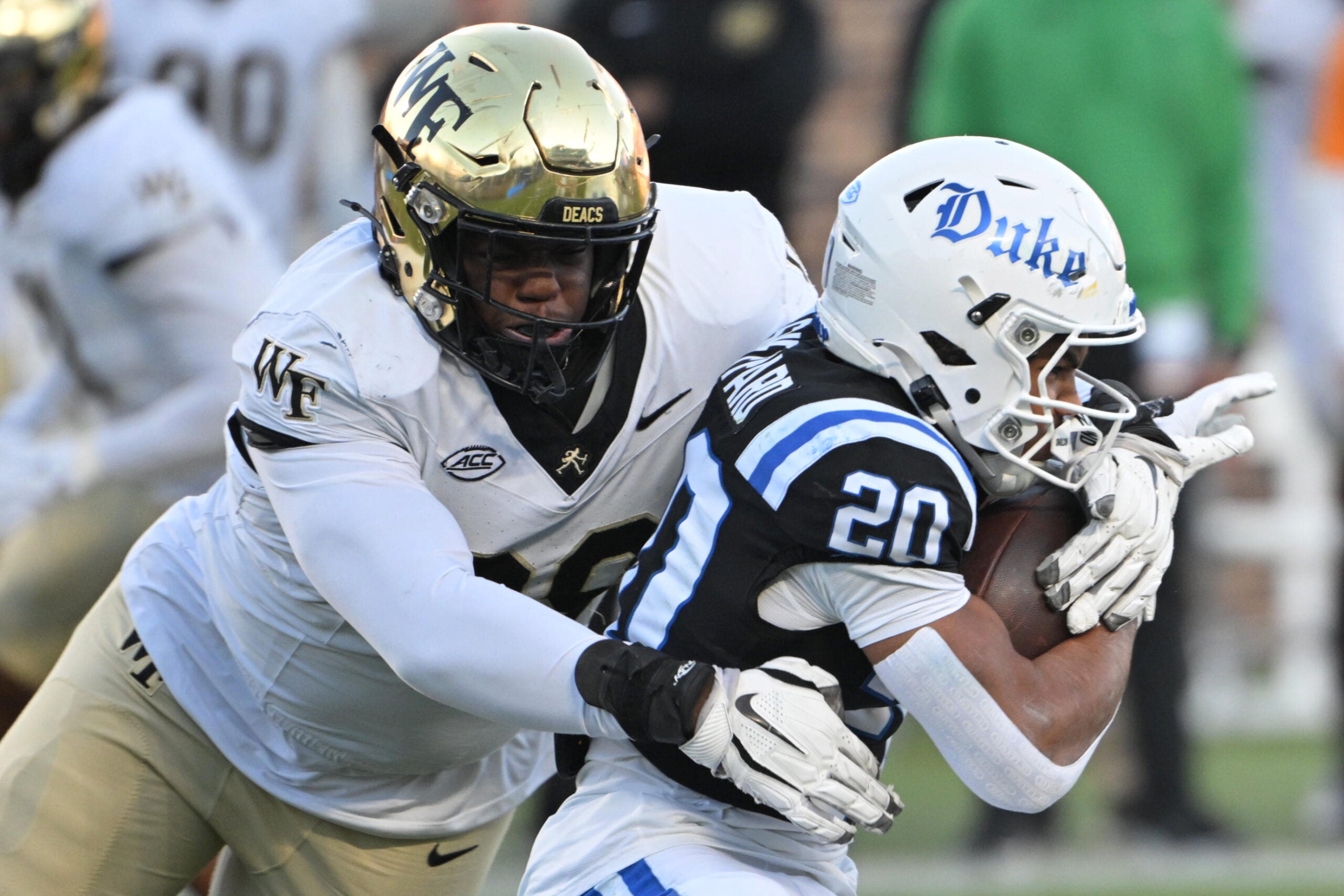 Nov 29, 2025; Durham, North Carolina, USA; Wake Forest Demon Deacons defensive lineman Mateen Ibirogba (99) tackles Duke Blue Devils running back Nate Sheppard (20) during the first quarter at Wallace Wade Stadium.