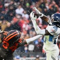 Dec 7, 2025; Cleveland, Ohio, USA; Tennessee Titans safety Xavier Woods (25) intercepts a pass intended for Cleveland Browns wide receiver Gage Larvadain (84) during the third quarter at Huntington Bank Field.