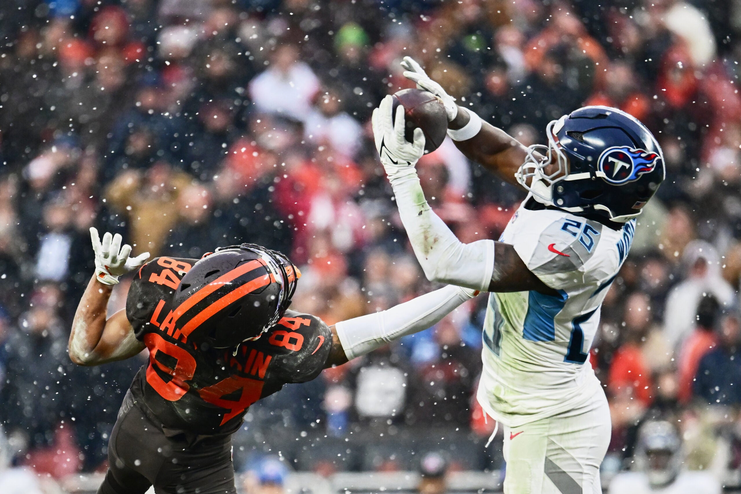 Dec 7, 2025; Cleveland, Ohio, USA; Tennessee Titans safety Xavier Woods (25) intercepts a pass intended for Cleveland Browns wide receiver Gage Larvadain (84) during the third quarter at Huntington Bank Field.