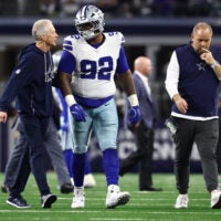 Dec 14, 2025; Arlington, Texas, USA; Dallas Cowboys defensive tackle Quinnen Williams (92) walks off the field with trainers after an injury during the second half against the Minnesota Vikings at AT&T Stadium.