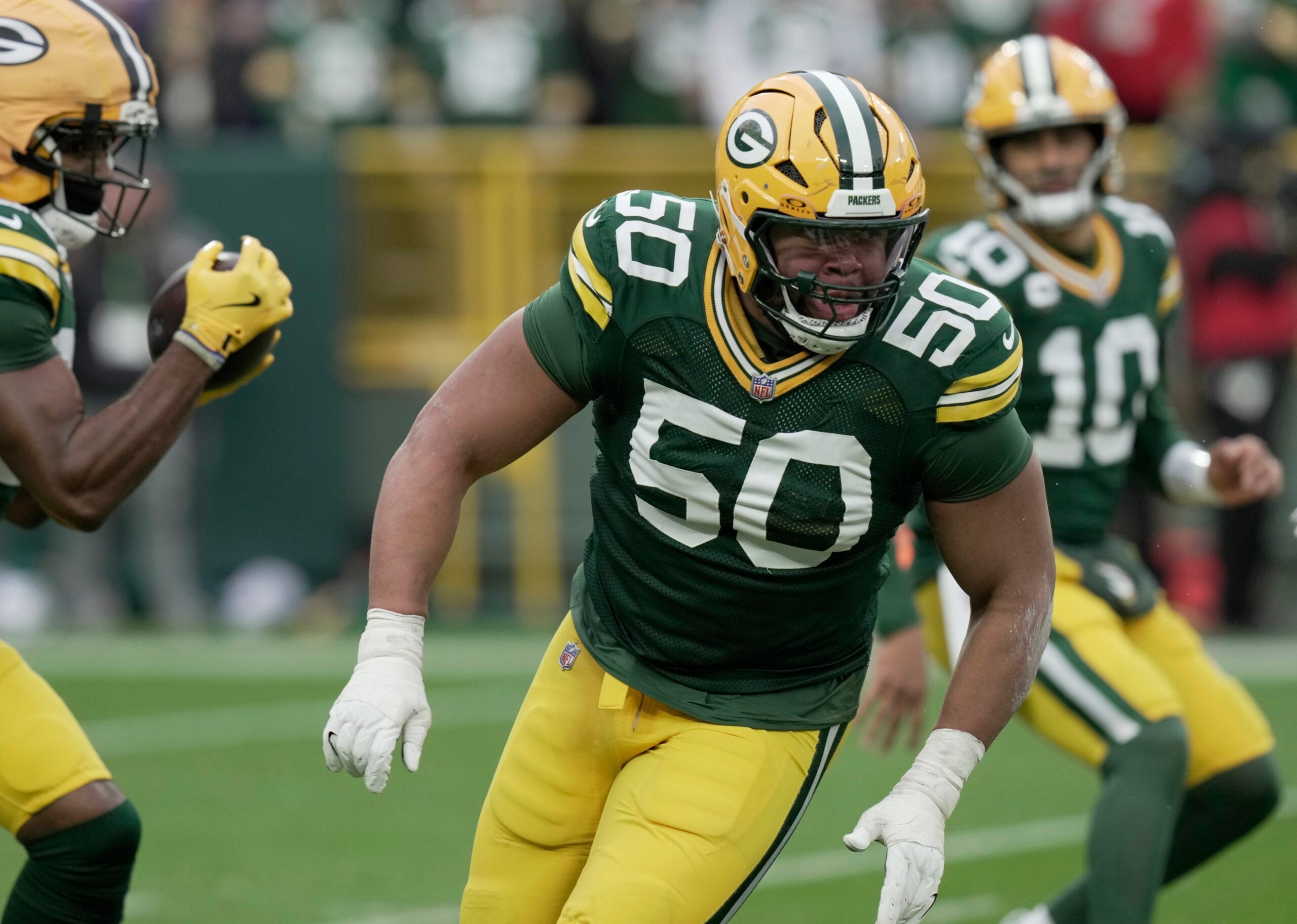 Green Bay Packers offensive tackle Zach Tom (50) leads a running back during the third quarter of their game against the Minnesota Vikings Sunday, November 23, 2025 at Lambeau Field in Green Bay, Wisconsin.