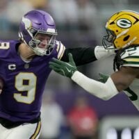 Minnesota Vikings quarterback J.J. McCarthy (9) stiff-arms Green Bay Packers linebacker Ty'Ron Hopper (59) after a seven yard run during the first quarter of their game Sunday, January 4, 2026 at U.S. Bank Stadium in Minneapolis, Minnesota.