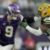Minnesota Vikings quarterback J.J. McCarthy (9) stiff-arms Green Bay Packers linebacker Ty'Ron Hopper (59) after a seven yard run during the first quarter of their game Sunday, January 4, 2026 at U.S. Bank Stadium in Minneapolis, Minnesota.