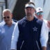 Jul 28, 2026; Oxnard, CA, USA; Dallas Cowboys coach Brian Schottenheimer walks with vice president of public relations and communications Tad Carper at training camp opening press conference at River Ridge Playing Fields.