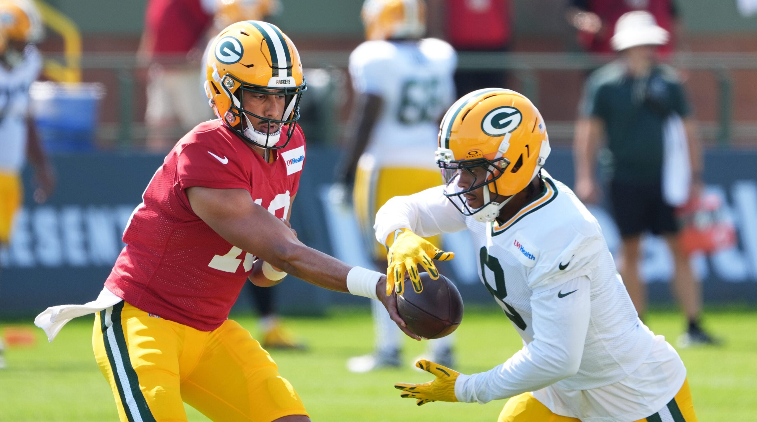 Green Bay Packers quarterback Jordan Love (10) hands off the ball to running back Josh Jacobs (8) during the fifth day of training camp on Aug. 3, 2026, at Ray Nitschke Field in Ashwaubenon, Wis.