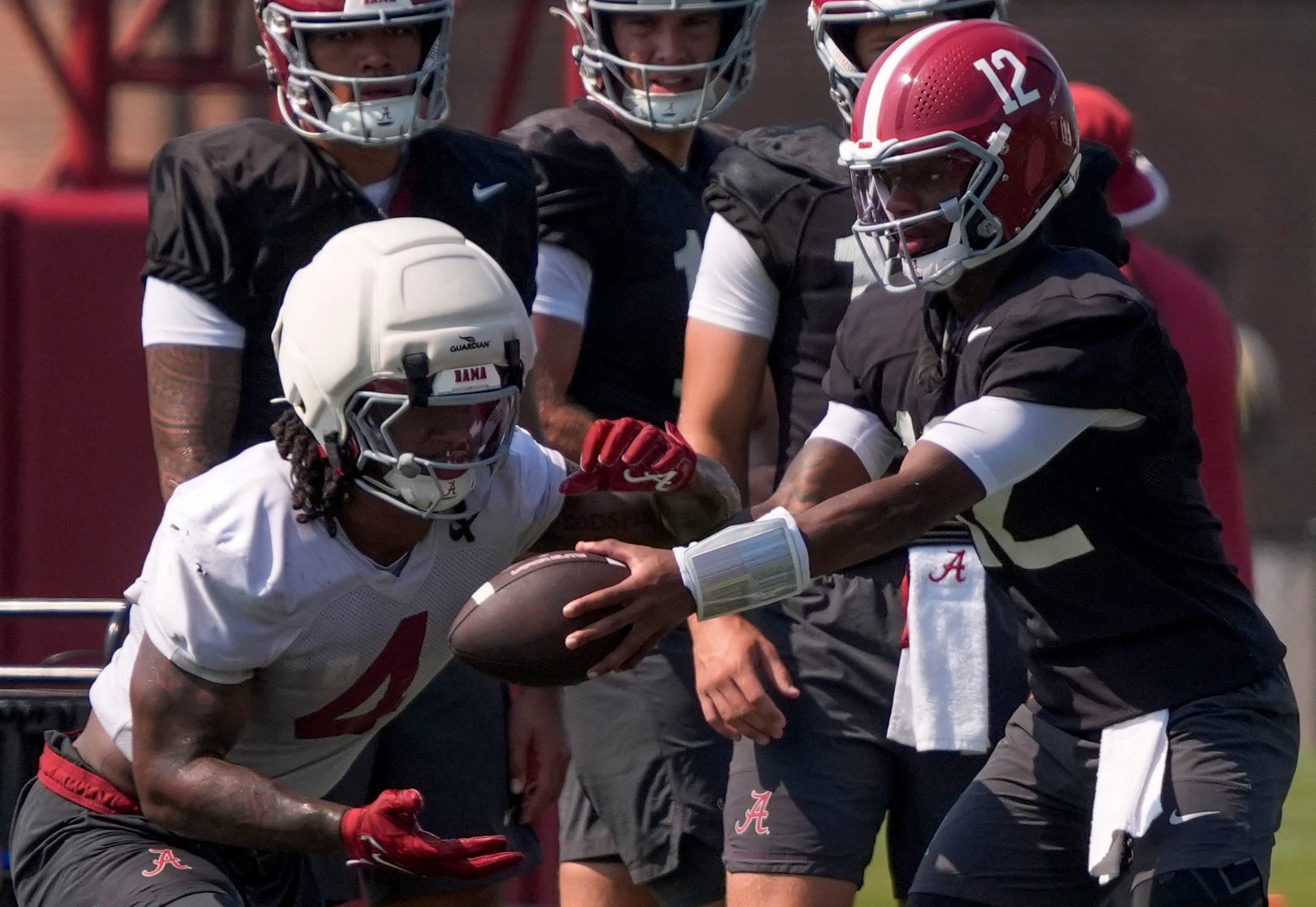 Aug. 6, 2026; Tuscaloosa, AL, USA; Quarterback Keelon Russell hands off to Daniel Hill during the Alabama Crimson Tide's first open practice session.