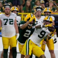 Green Bay Packers wide receiver Christian Watson (9) catches a pass with pressure from cornerback Brandon Cisse (2) during Green Bay Packers Family Night on Aug. 7, 2026, at Lambeau Field in Green Bay, Wis.