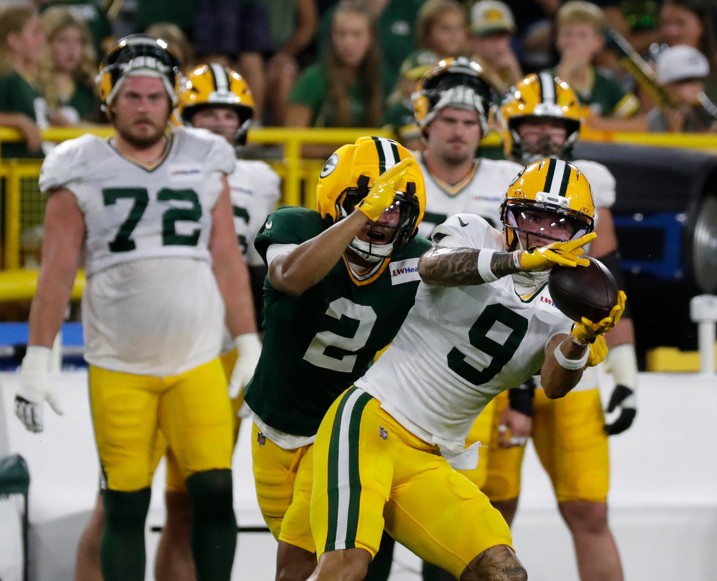 Green Bay Packers wide receiver Christian Watson (9) catches a pass with pressure from cornerback Brandon Cisse (2) during Green Bay Packers Family Night on Aug. 7, 2026, at Lambeau Field in Green Bay, Wis.