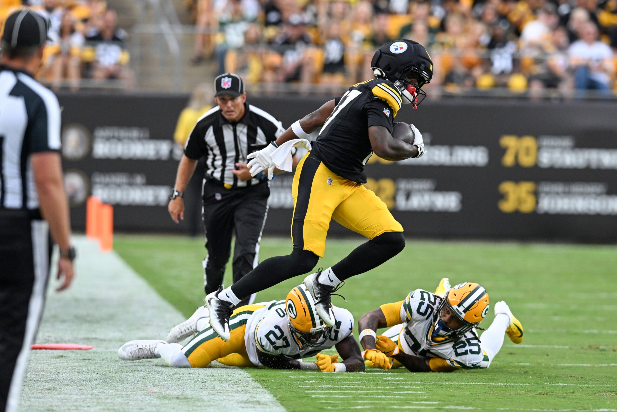 Aug 13, 2026; Pittsburgh, Pennsylvania, USA; Pittsburgh Steelers wide receiver Germie Bernard (17) jumps over Green Bay Packers safety Kitan Oladapo (27) during the first half of a game against the Green Bay Packers at Acrisure Stadium.