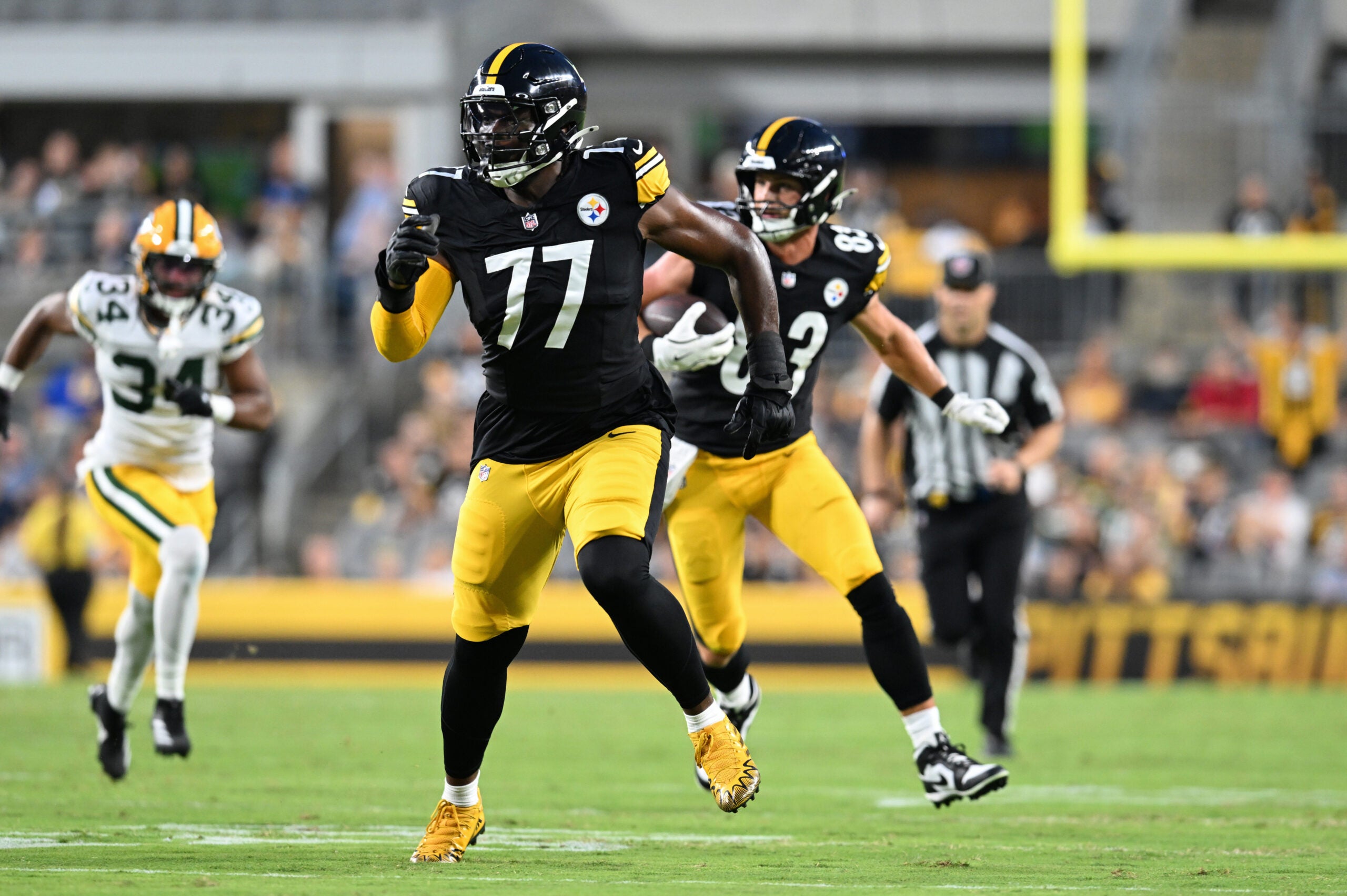 Aug 13, 2026; Pittsburgh, Pennsylvania, USA; Pittsburgh Steelers offensive tackle Broderick Jones (77) looks for someone to block as tight end Robert Tonyan (83) carries the ball during the first half of a game against the Green Bay Packers at Acrisure Stadium.