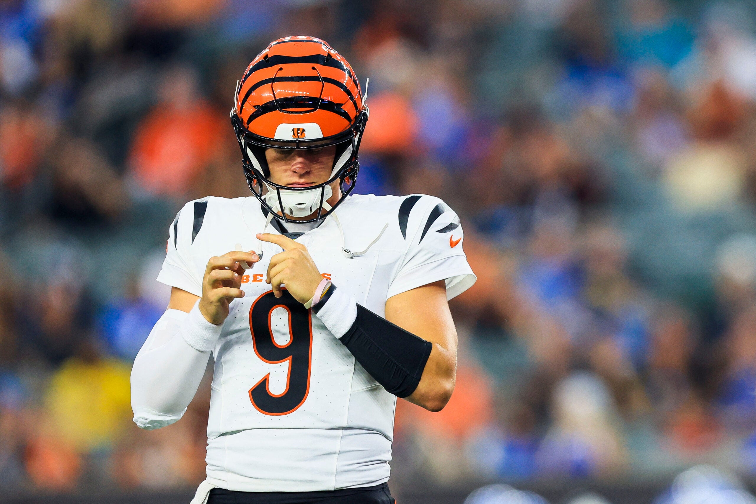 Aug 13, 2026; Cincinnati, Ohio, USA; Cincinnati Bengals quarterback Joe Burrow (9) adjusts his helmet during a stop in play in the first half against the Detroit Lions at Paycor Stadium.