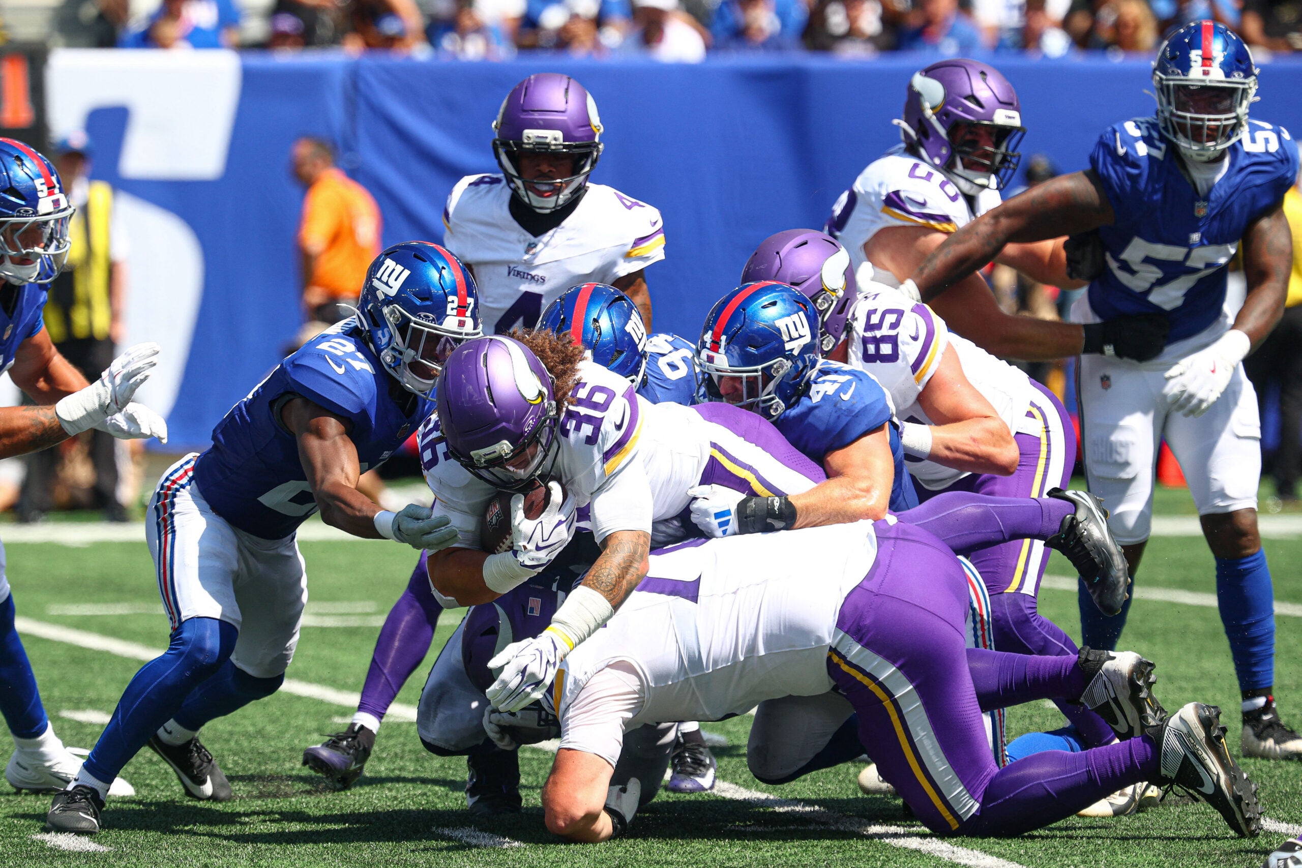 Aug 15, 2026; East Rutherford, New Jersey, USA; Minnesota Vikings running back Zavier Scott (36) is tackled by New York Giants safety Tyler Nubin (27) and defensive tackle Josh Tupou (94) during the first half at MetLife Stadium.
