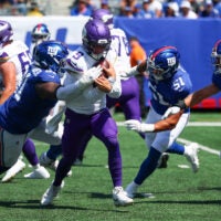 Aug 15, 2026; East Rutherford, New Jersey, USA; Minnesota Vikings quarterback J.J. McCarthy (9) is sacked by New York Giants defensive tackle Darius Alexander (91) during the first half at MetLife Stadium.