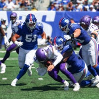 Aug 15, 2026; East Rutherford, New Jersey, USA; Minnesota Vikings quarterback J.J. McCarthy (9) is sacked by New York Giants defensive tackle Darius Alexander (91) during the first half at MetLife Stadium.