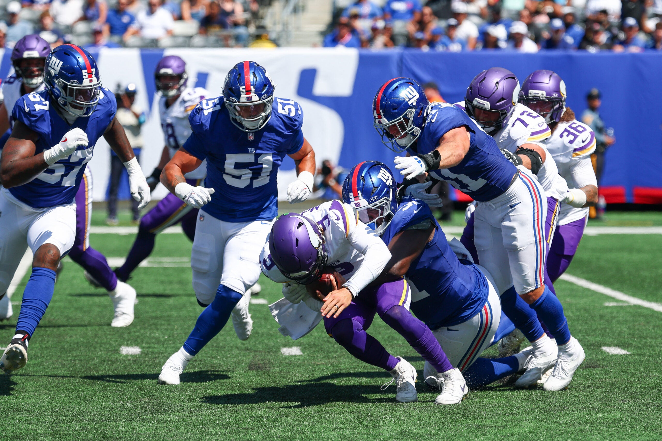 Aug 15, 2026; East Rutherford, New Jersey, USA; Minnesota Vikings quarterback J.J. McCarthy (9) is sacked by New York Giants defensive tackle Darius Alexander (91) during the first half at MetLife Stadium.