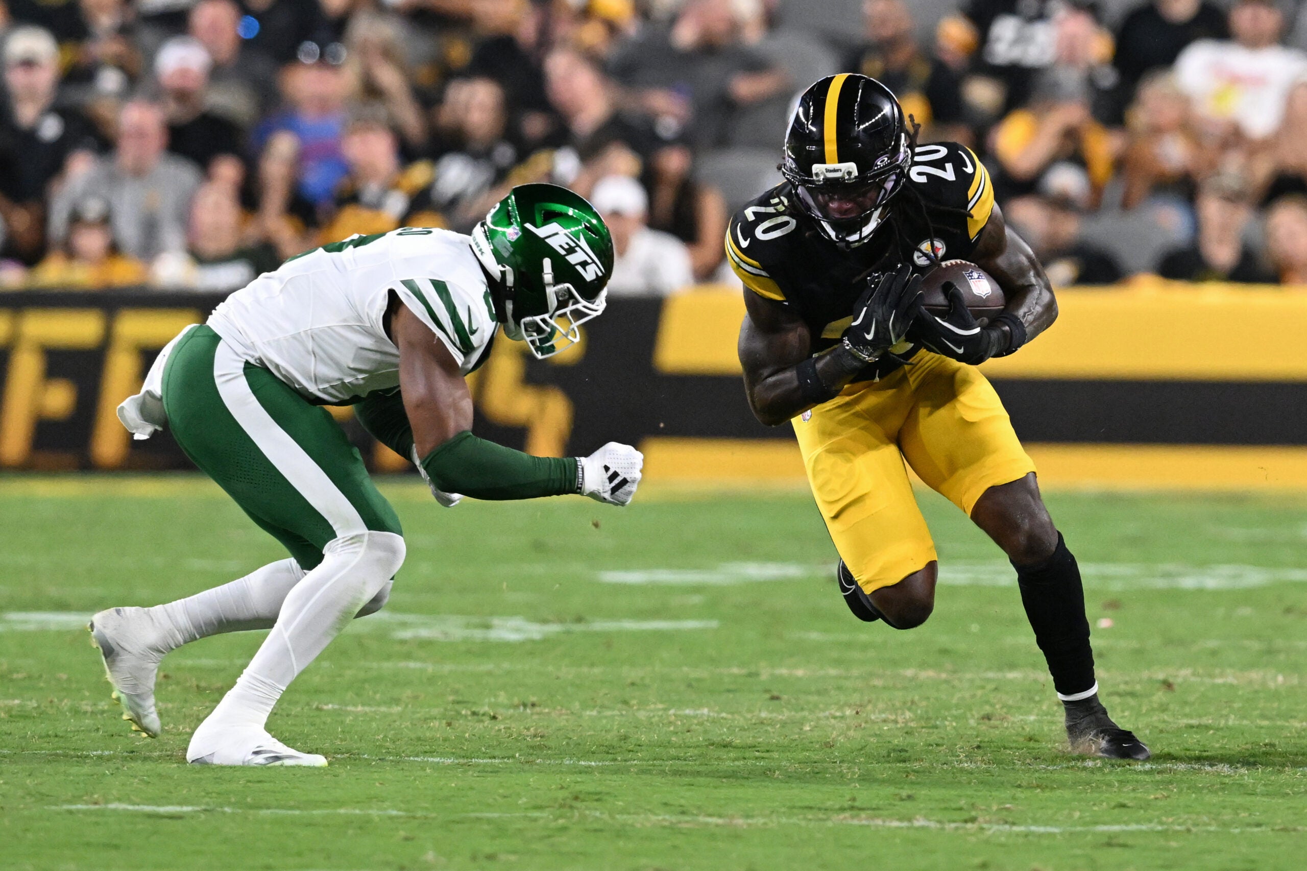 Aug 21, 2026; Pittsburgh, Pennsylvania, USA; Pittsburgh Steelers running back Kaleb Johnson (20) is tackled by New York Jets safety Andre Cisco (8) during the third quarter at Acrisure Stadium.