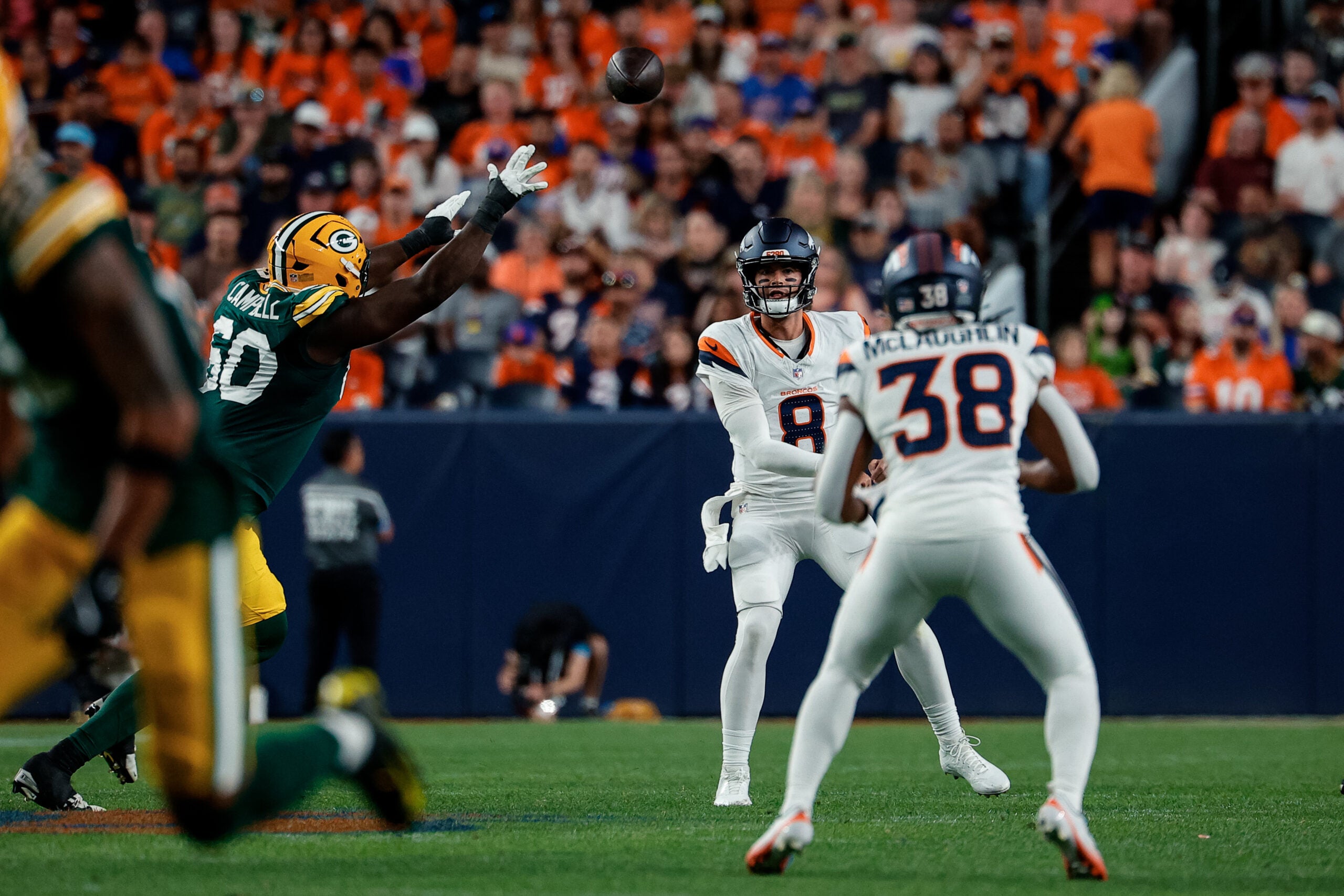 Aug 21, 2026; Denver, Colorado, USA; Denver Broncos quarterback Jarrett Stidham (8) passes to running back Jaleel McLaughlin (38) as Green Bay Packers defensive tackle Anthony Campbell (60) defends in the second quarter at Empower Field at Mile High.