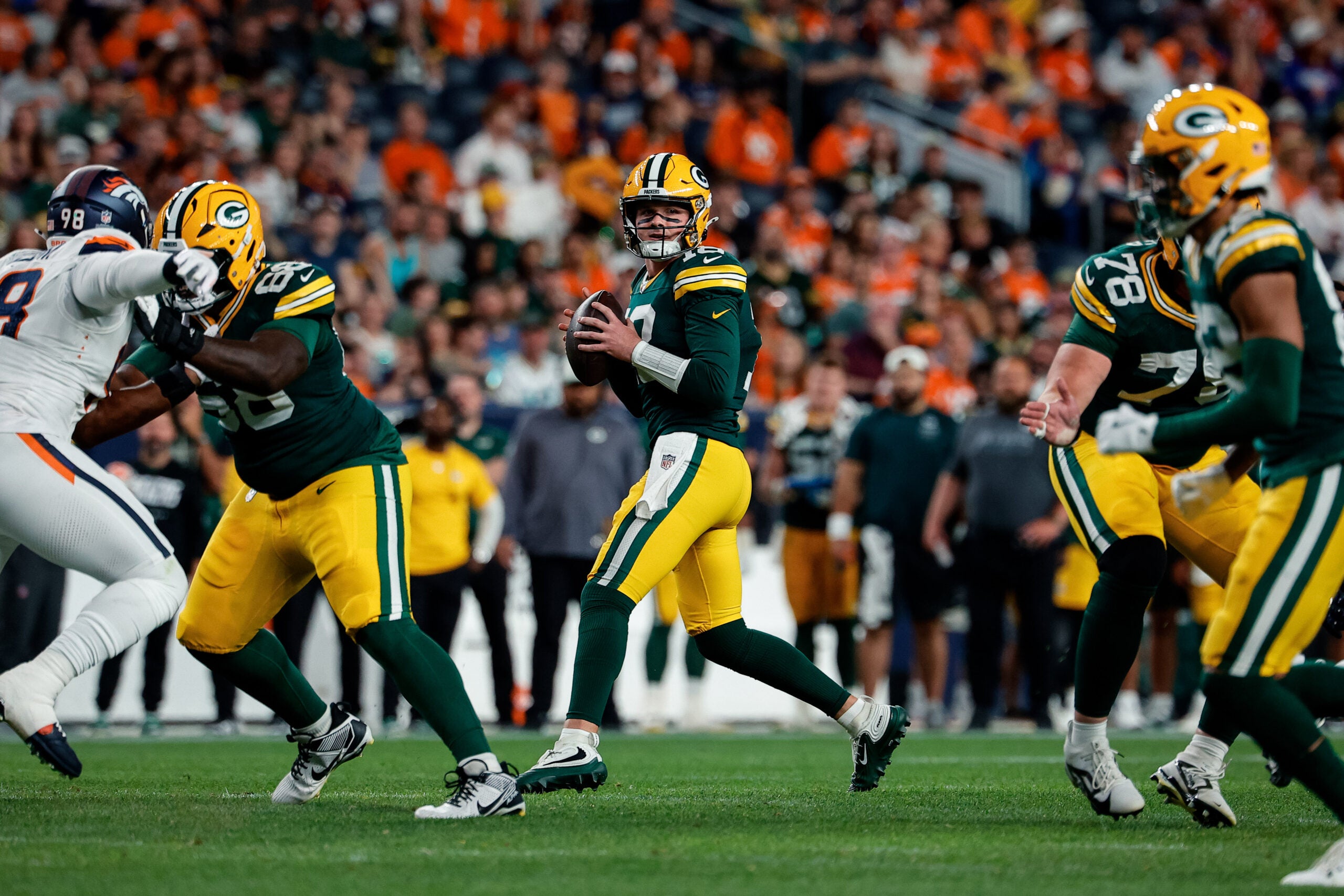 Aug 21, 2026; Denver, Colorado, USA; Green Bay Packers quarterback Kyle McCord (18) drops back in the fourth quarter against the Denver Broncos at Empower Field at Mile High.