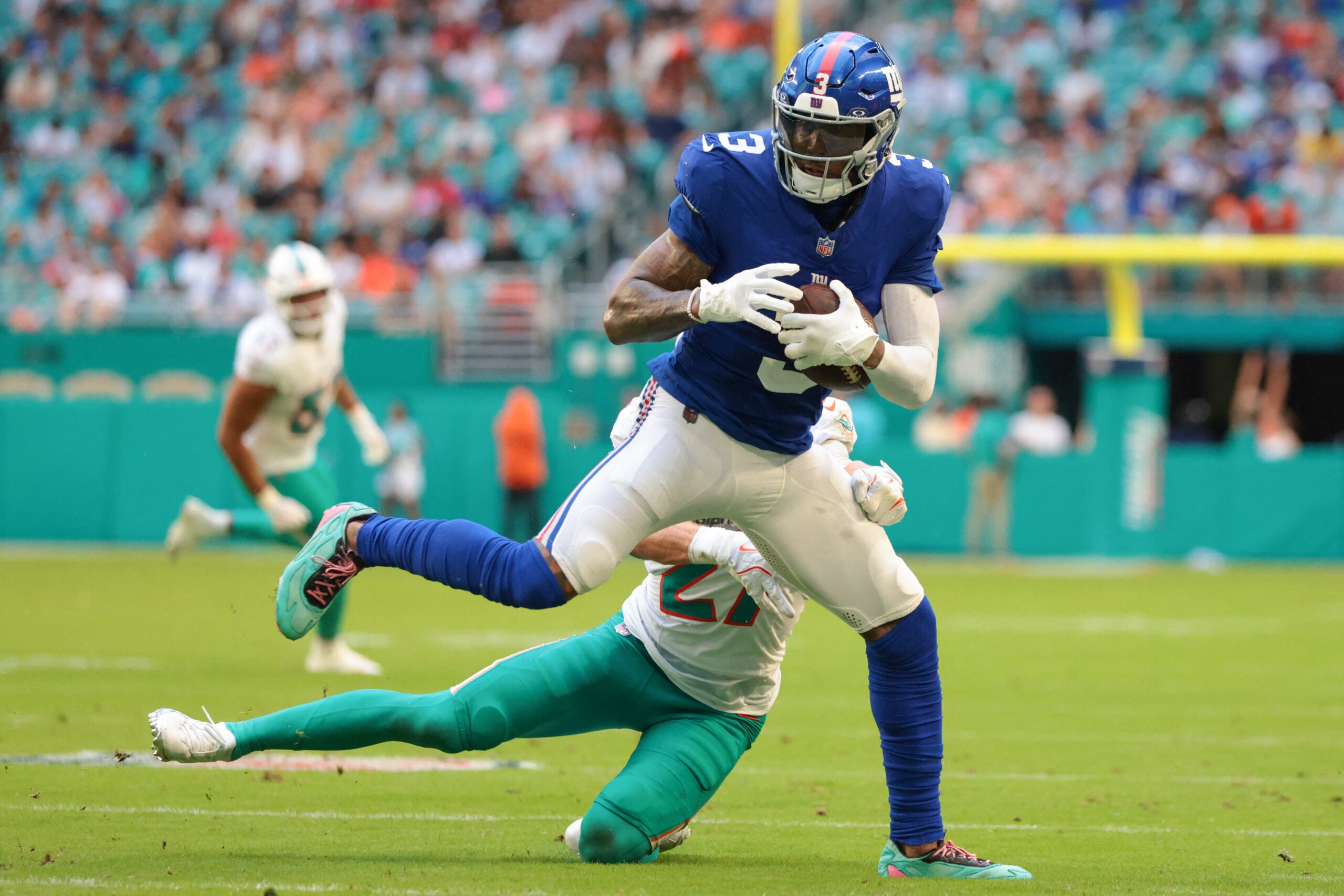 Aug 22, 2026; Miami Gardens, Florida, USA; New York Giants wide receiver Odell Beckham Jr. (3) breaks a tackle against Miami Dolphins cornerback Ethan Bonner (27) during the first half at Hard Rock Stadium.