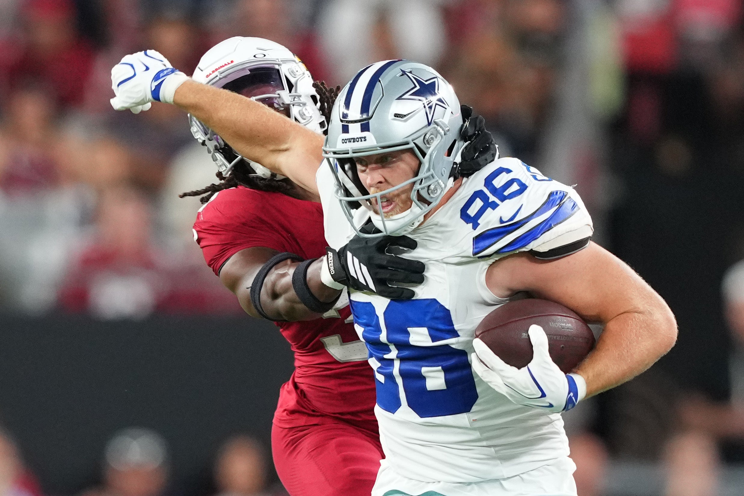 Aug 22, 2026; Glendale, Arizona, USA; Dallas Cowboys tight end Luke Schoonmaker (86) delivers a stiff arm to Arizona Cardinals safety Kitan Crawford (36) during the first half at State Farm Stadium.