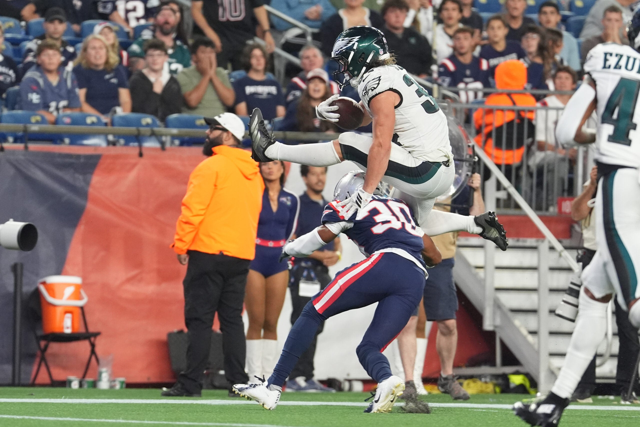 Aug 22, 2026; Foxborough, Massachusetts, USA; Philadelphia Eagles running back Carson Steele (34) leaps over New England Patriots safety Eric Butler (30) and scores a touchdown during the second half at Gillette Stadium.