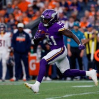 Aug 28, 2026; Denver, Colorado, USA; Minnesota Vikings running back Demond Claiborne (21) runs the ball in the first quarter against the Denver Broncos at Empower Field at Mile High.