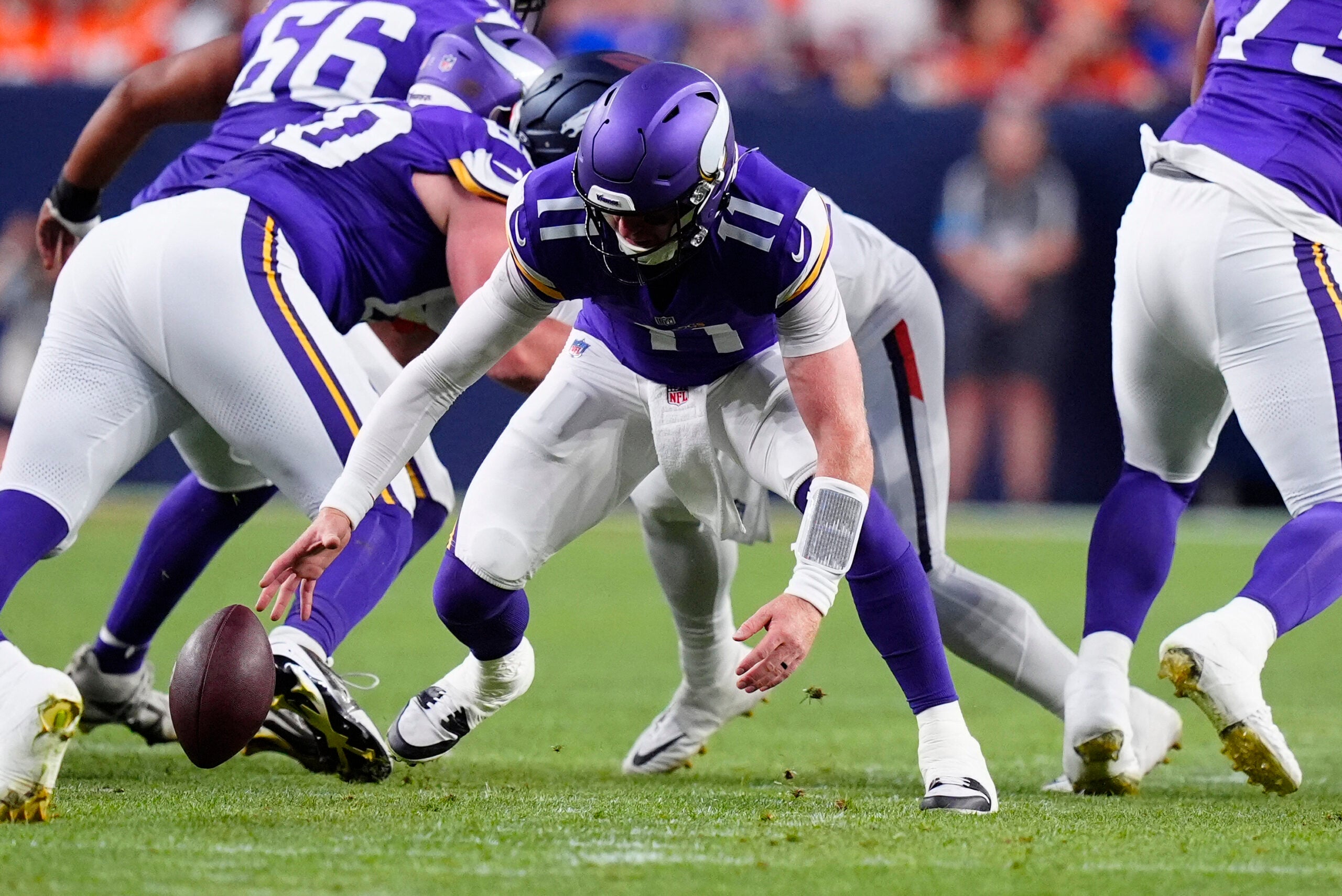 Aug 28, 2026; Denver, Colorado, USA; Minnesota Vikings quarterback Carson Wentz (11) fumbles the ball in the first quarter against the Denver Broncos during a preseason game at Empower Field at Mile High.