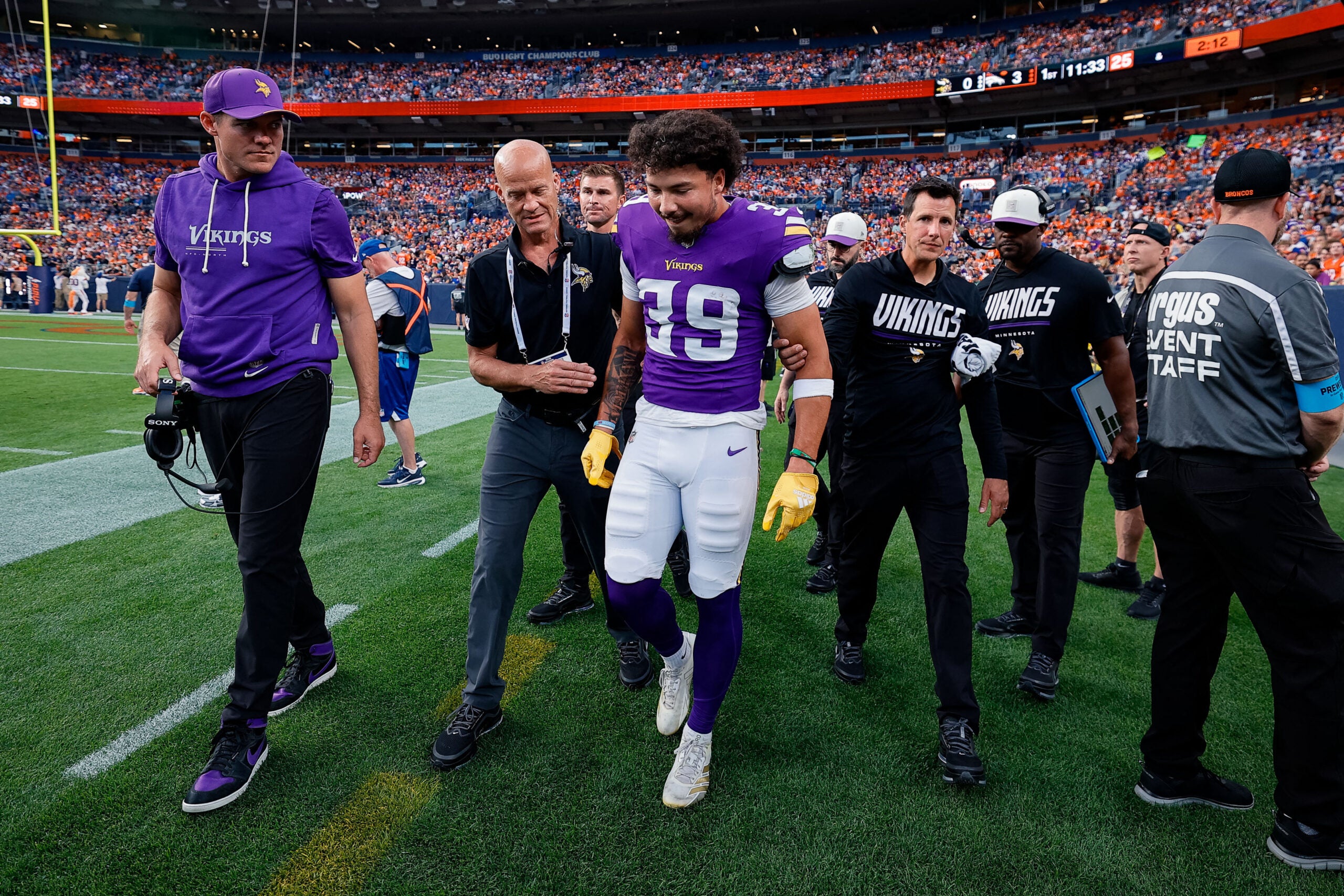 Aug 28, 2026; Denver, Colorado, USA; Minnesota Vikings safety Jacob Thomas (39) is helped after a play in the first quarter against the Denver Broncos at Empower Field at Mile High.