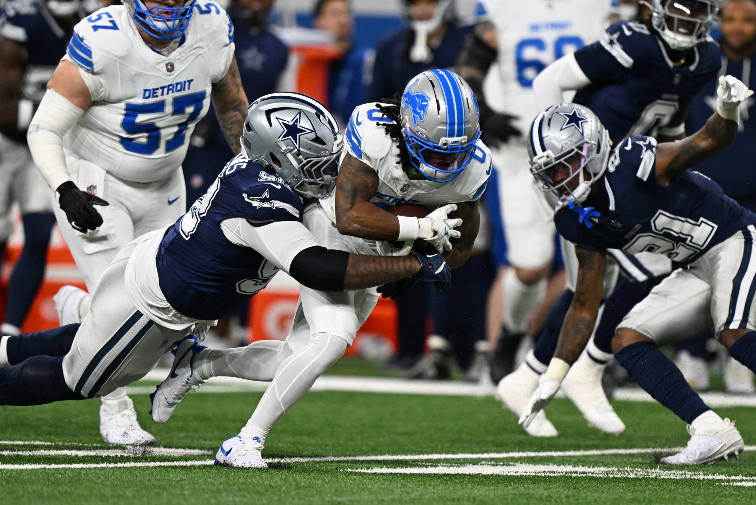 Dec 4, 2025; Detroit, Michigan, USA; Detroit Lions running back Jahmyr Gibbs (0) is tackled by Dallas Cowboys defensive tackle Quinnen Williams (92) during the first half at Ford Field.