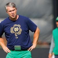 Notre Dame quarterbacks coach Gino Guidugli watches players warm up during a Notre Dame football practice at Irish Athletic Center on Tuesday, Aug. 6, 2024, in South Bend.