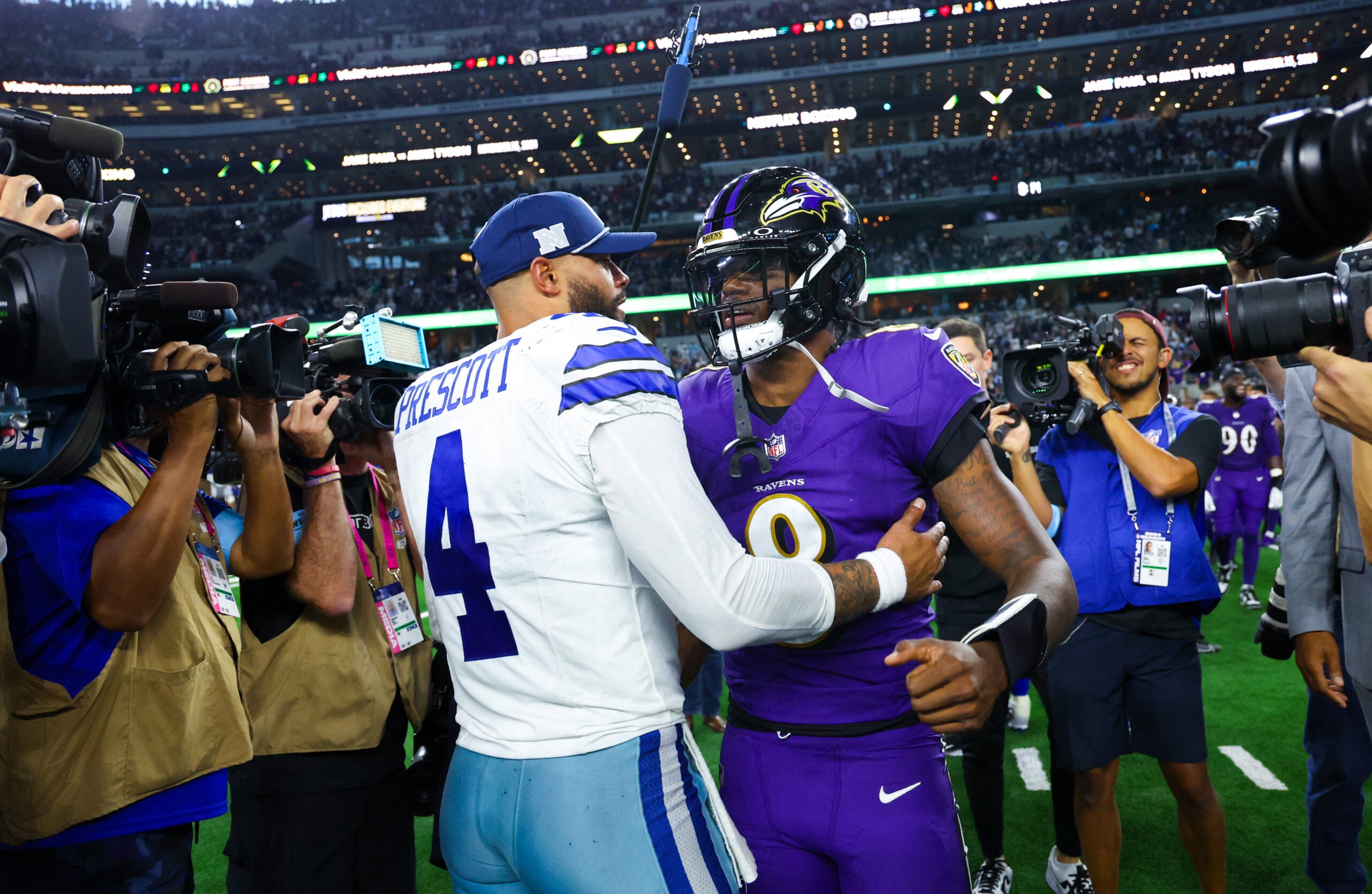 Sep 22, 2024; Arlington, Texas, USA; Dallas Cowboys quarterback Dak Prescott (4) hugs Baltimore Ravens quarterback Lamar Jackson (8) after the game at AT&T Stadium.