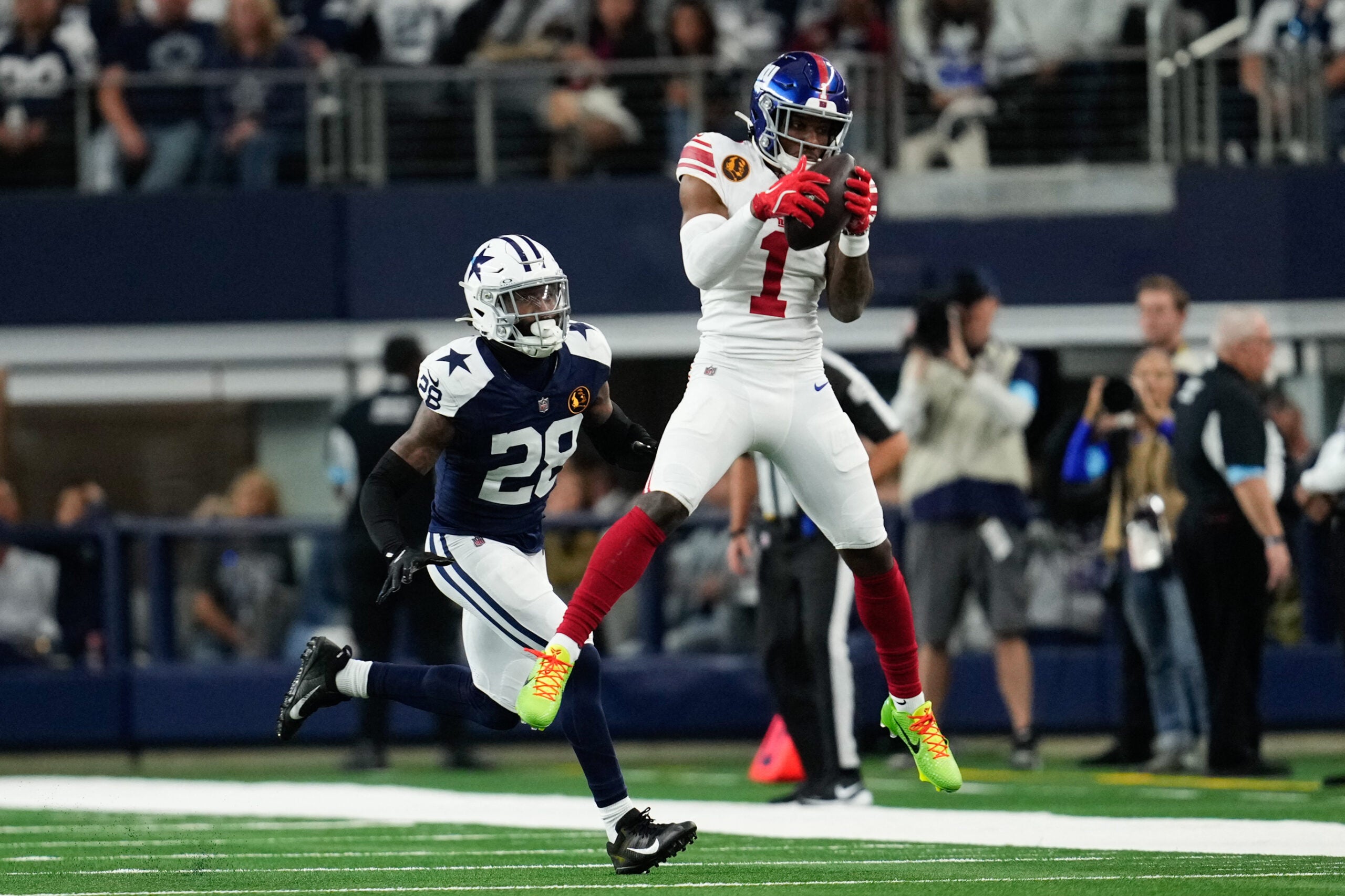 Nov 28, 2024; Arlington, Texas, USA; New York Giants wide receiver Malik Nabers (1) catches a pass as Dallas Cowboys safety Malik Hooker (28) gives chase during the first half at AT&T Stadium.