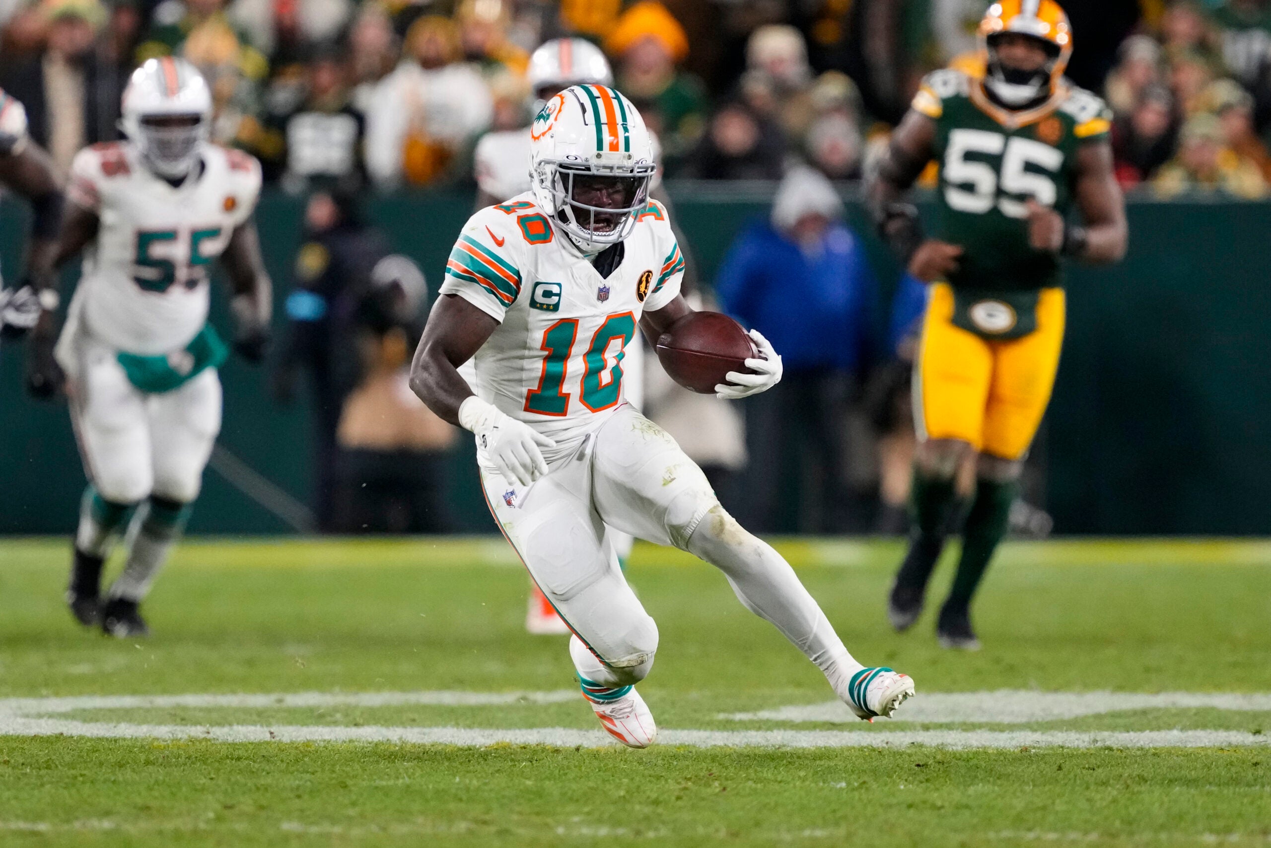 Nov 28, 2024; Green Bay, Wisconsin, USA; Miami Dolphins wide receiver Tyreek Hill (10) rushes with the football during the fourth quarter against the Green Bay Packers at Lambeau Field.