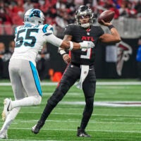 Jan 5, 2025; Atlanta, Georgia, USA; Atlanta Falcons quarterback Michael Penix Jr. (9) passes over Carolina Panthers defensive end Kenny Dyson Jr. (55) during the first quarter at Mercedes-Benz Stadium.