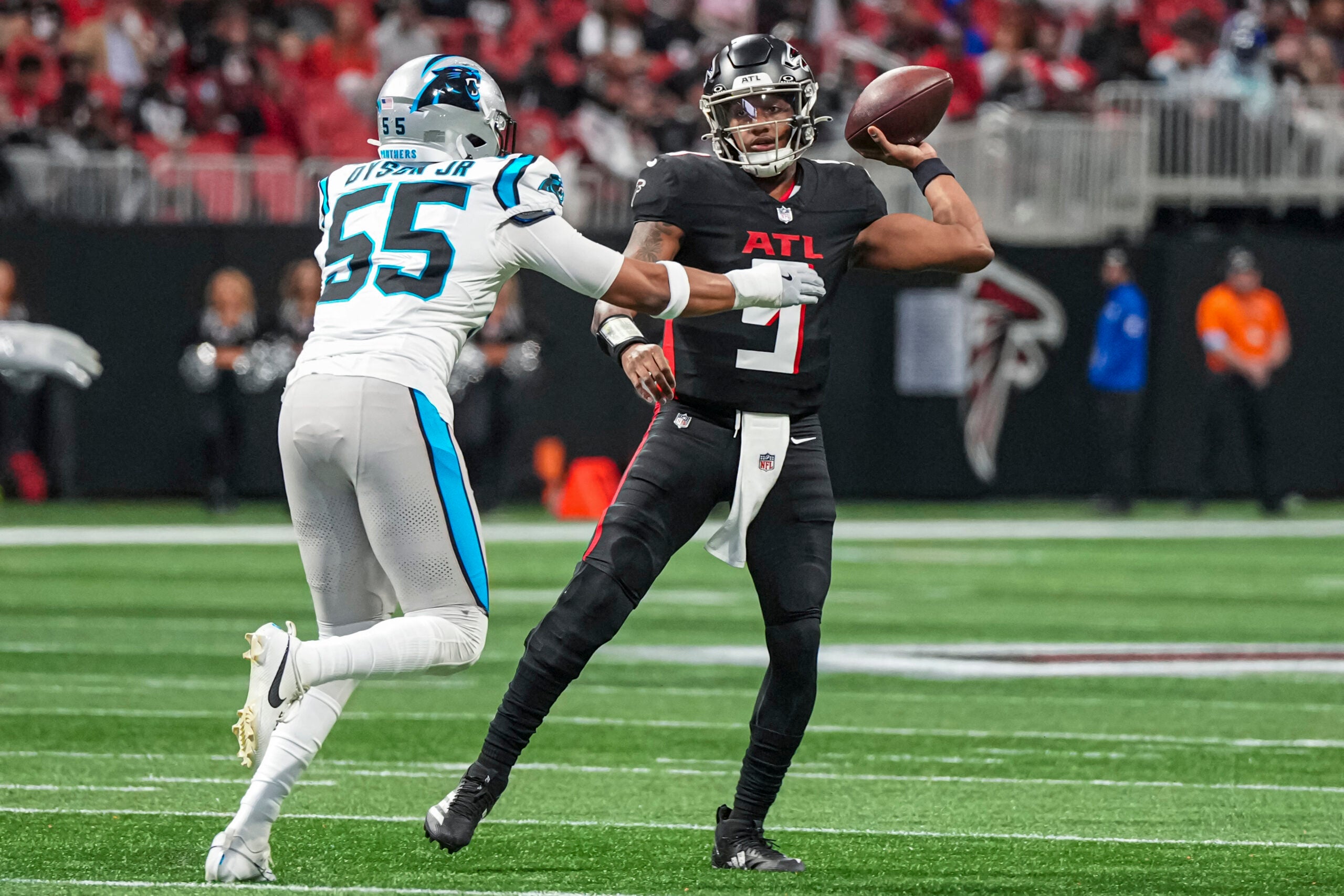 Jan 5, 2025; Atlanta, Georgia, USA; Atlanta Falcons quarterback Michael Penix Jr. (9) passes over Carolina Panthers defensive end Kenny Dyson Jr. (55) during the first quarter at Mercedes-Benz Stadium.