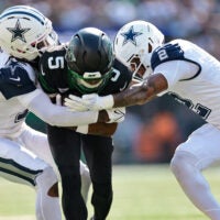 Oct 5, 2025; East Rutherford, New Jersey, USA; New York Jets wide receiver Garrett Wilson (5) is tackled by Dallas Cowboys cornerback Trevon Diggs (7) and safety Juanyeh Thomas (2) during the first half at MetLife Stadium.