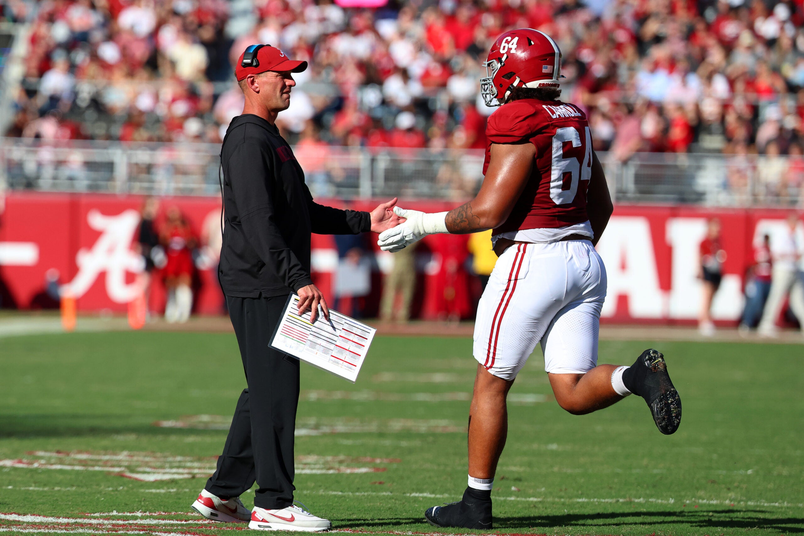 Nov 22, 2025; Tuscaloosa, Alabama, USA; Alabama Crimson Tide head coach Kalen DeBoer high fives Alabama Crimson Tide offensive lineman Michael Carroll (64) during the first half against the Eastern Illinois Panthers at Saban Field at Bryant-Denny Stadium.