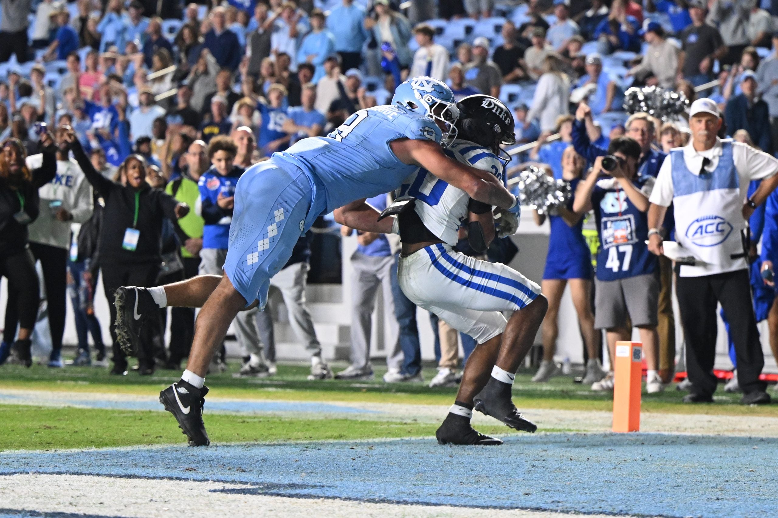 Nov 22, 2025; Chapel Hill, North Carolina, USA; Duke Blue Devils running back Nate Sheppard (20) scores with North Carolina Tar Heels defensive lineman Melkart Abou Jaoude (9) wrapped around him during the second half at Kenan Stadium.