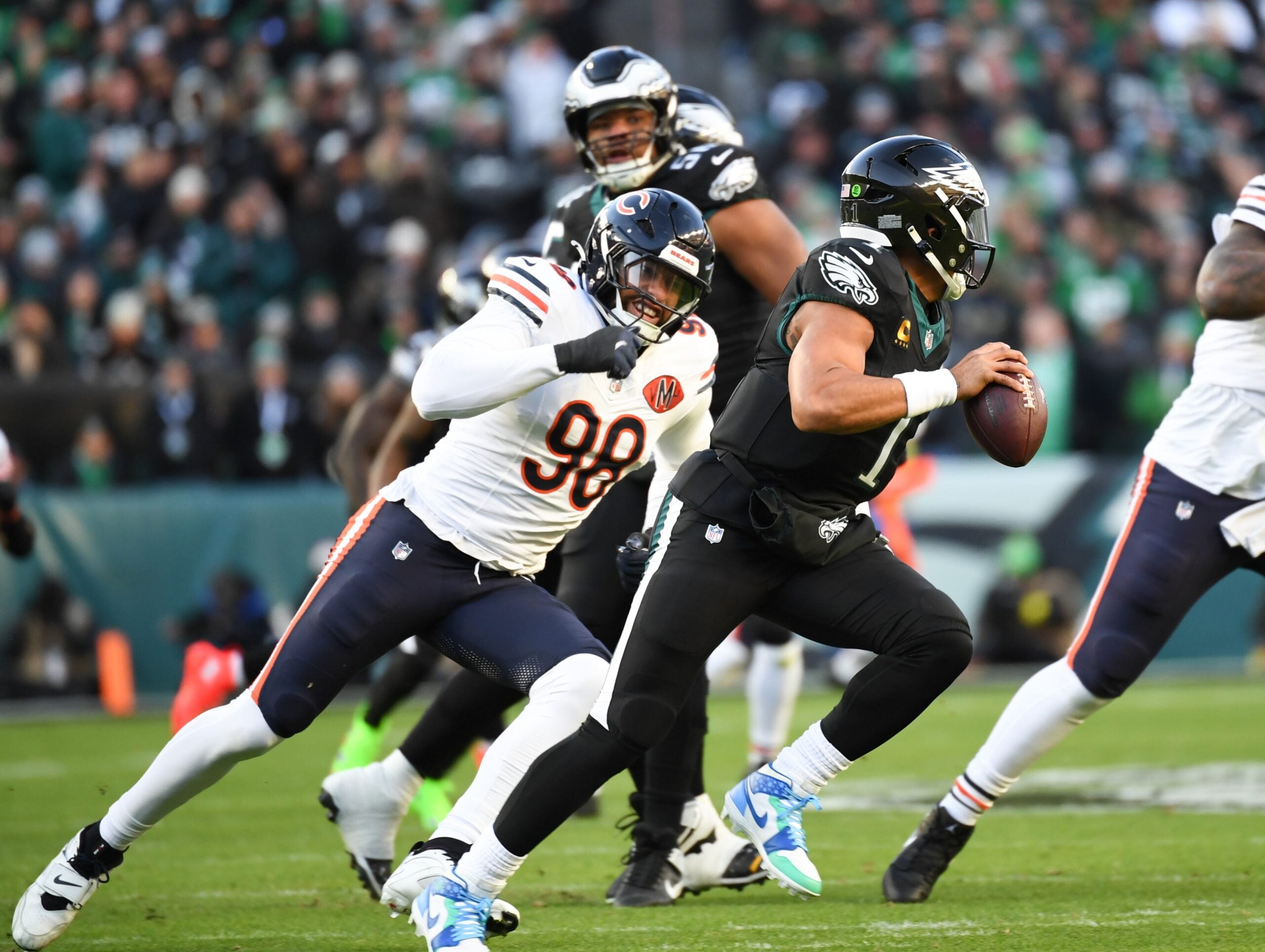 Nov 28, 2025; Philadelphia, Pennsylvania, USA; Philadelphia Eagles quarterback Jalen Hurts (1) scrambles with the ball defended by Chicago Bears defensive end Montez Sweat (98) during the first quarter of the game at Lincoln Financial Field.