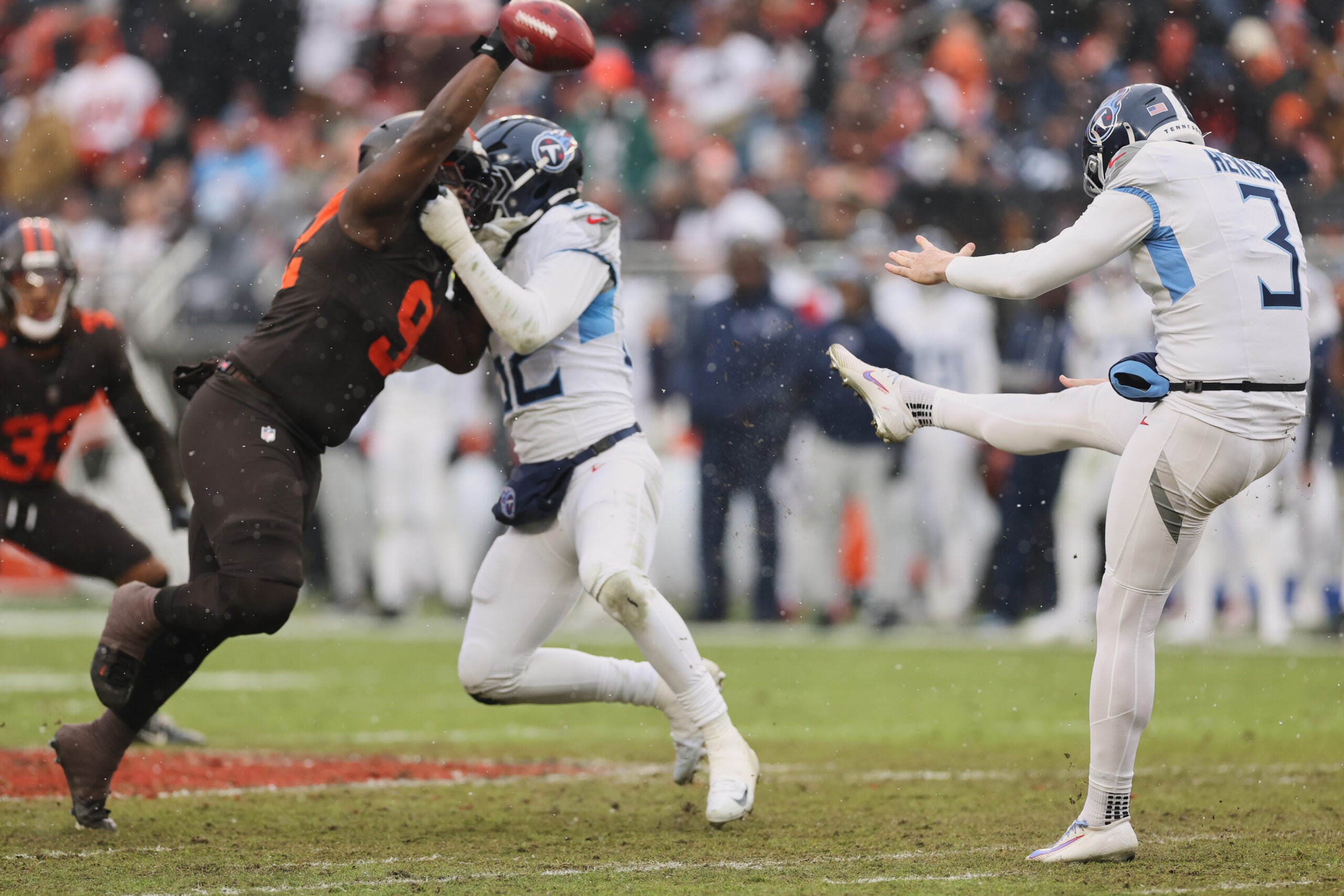 Dec 7, 2025; Cleveland, Ohio, USA; Tennessee Titans punter Johnny Hekker (3) punts the ball against Cleveland Browns defensive tackle Sam Kamara (92) during the second quarter at Huntington Bank Field.