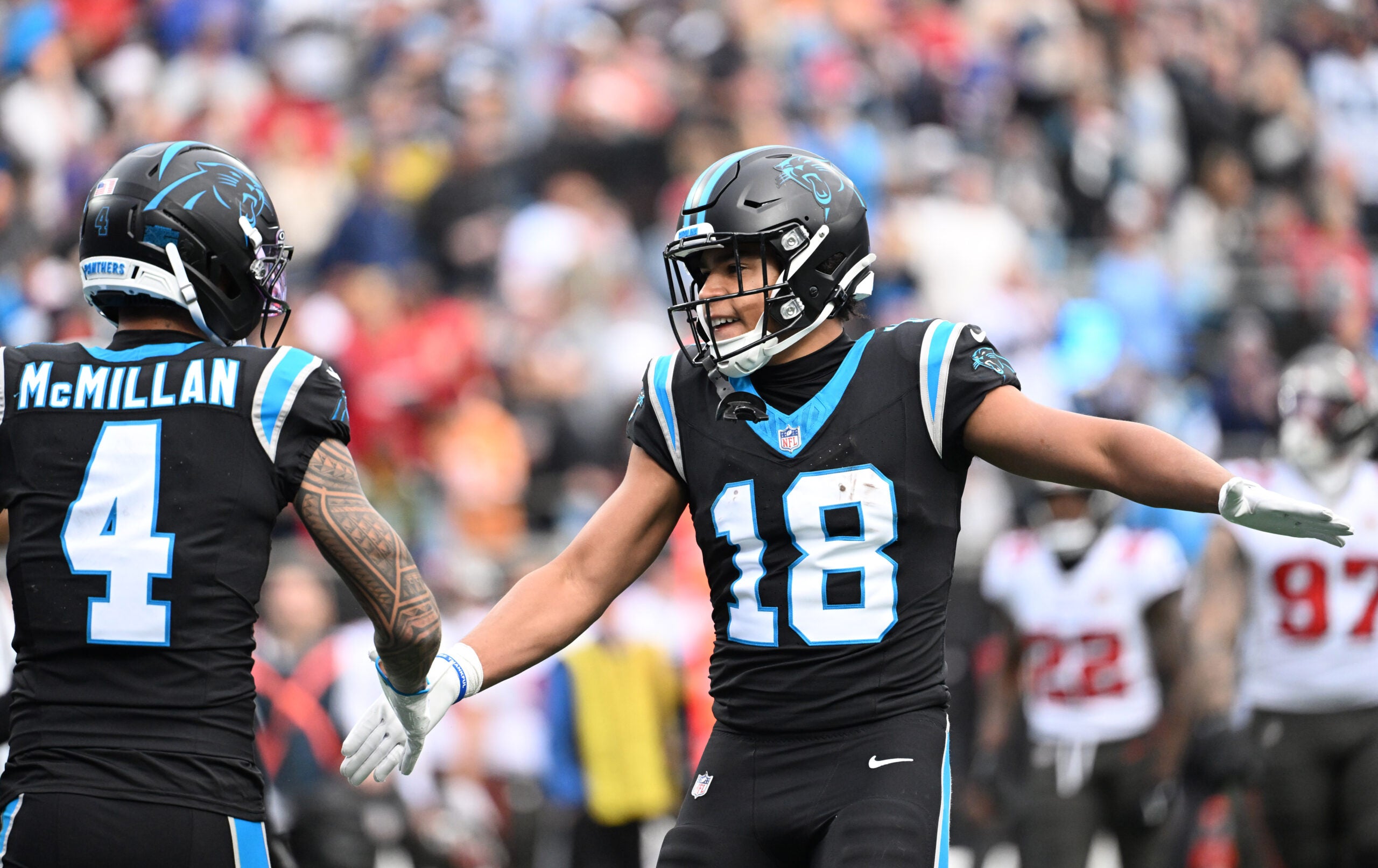Dec 21, 2025; Charlotte, North Carolina, USA; Carolina Panthers wide receiver Jalen Coker (18) celebrates with wide receiver Tetairoa McMillan (4) after a play during the first half against the Tampa Bay Buccaneers at Bank of America Stadium.